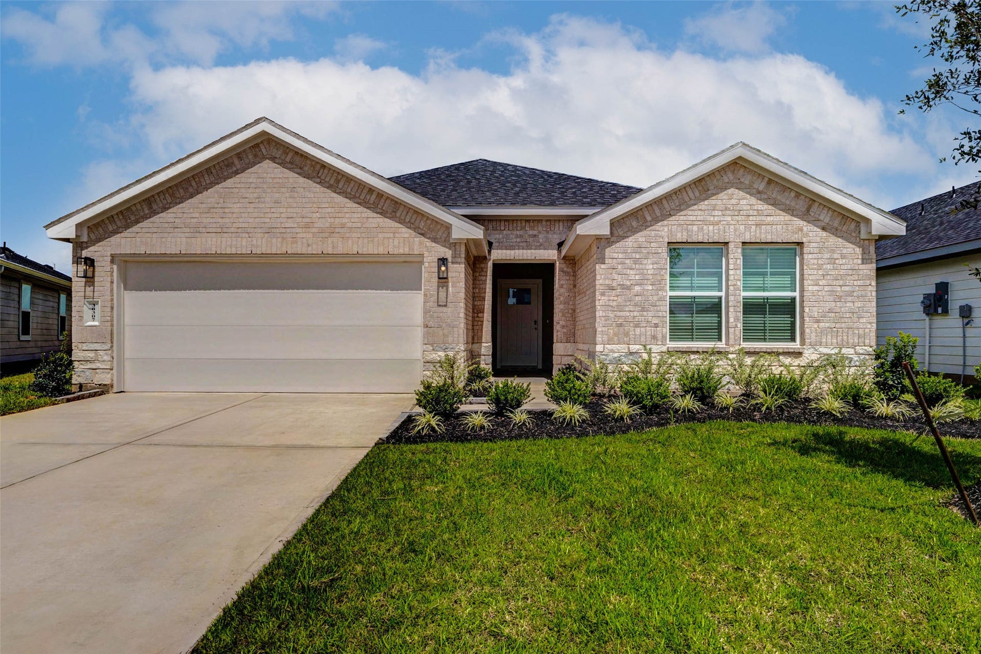 30307 Lighthouse Bluff Lane, Fulshear, TX 77441 This charming single-story brick home features a clean, modern exterior with a two-car garage, well-maintained lawn, and neat landscaping.