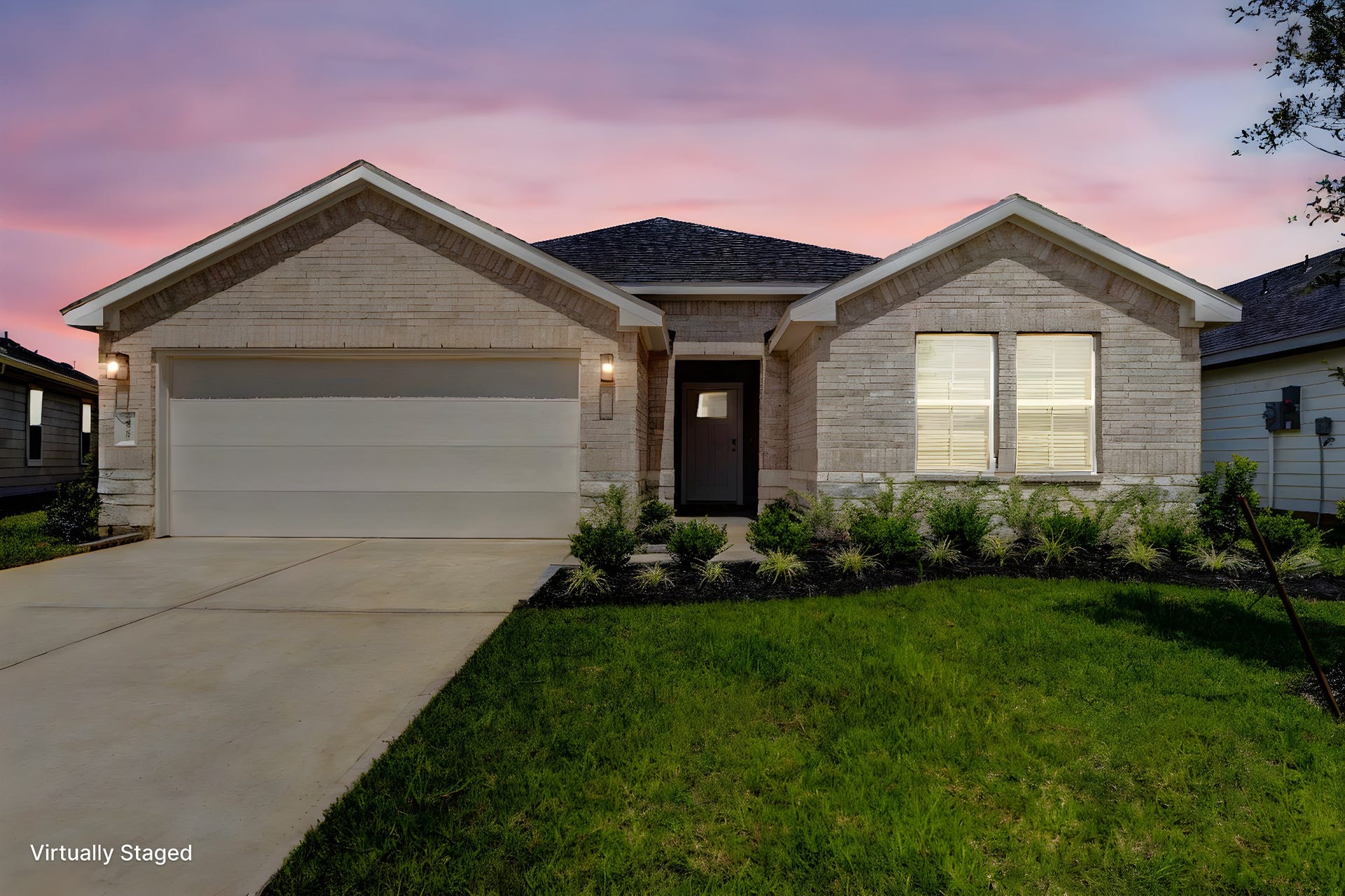 30307 Lighthouse Bluff Lane, Fulshear, TX 77441 Modern, single-story home with a brick exterior and a two-car garage. The front yard is landscaped with shrubs, and the home is set against a beautiful sunset sky.