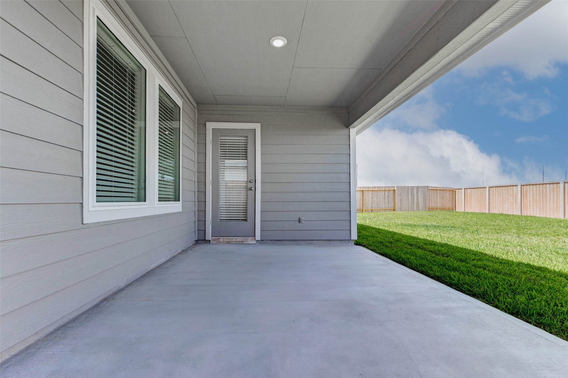 30307 Lighthouse Bluff Lane, Fulshear, TX 77441 Nice covered patio with a concrete floor, adjacent to a grassy backyard enclosed by a wooden fence, offering a private outdoor space for relaxation or entertaining. Fully sprinklered back and front