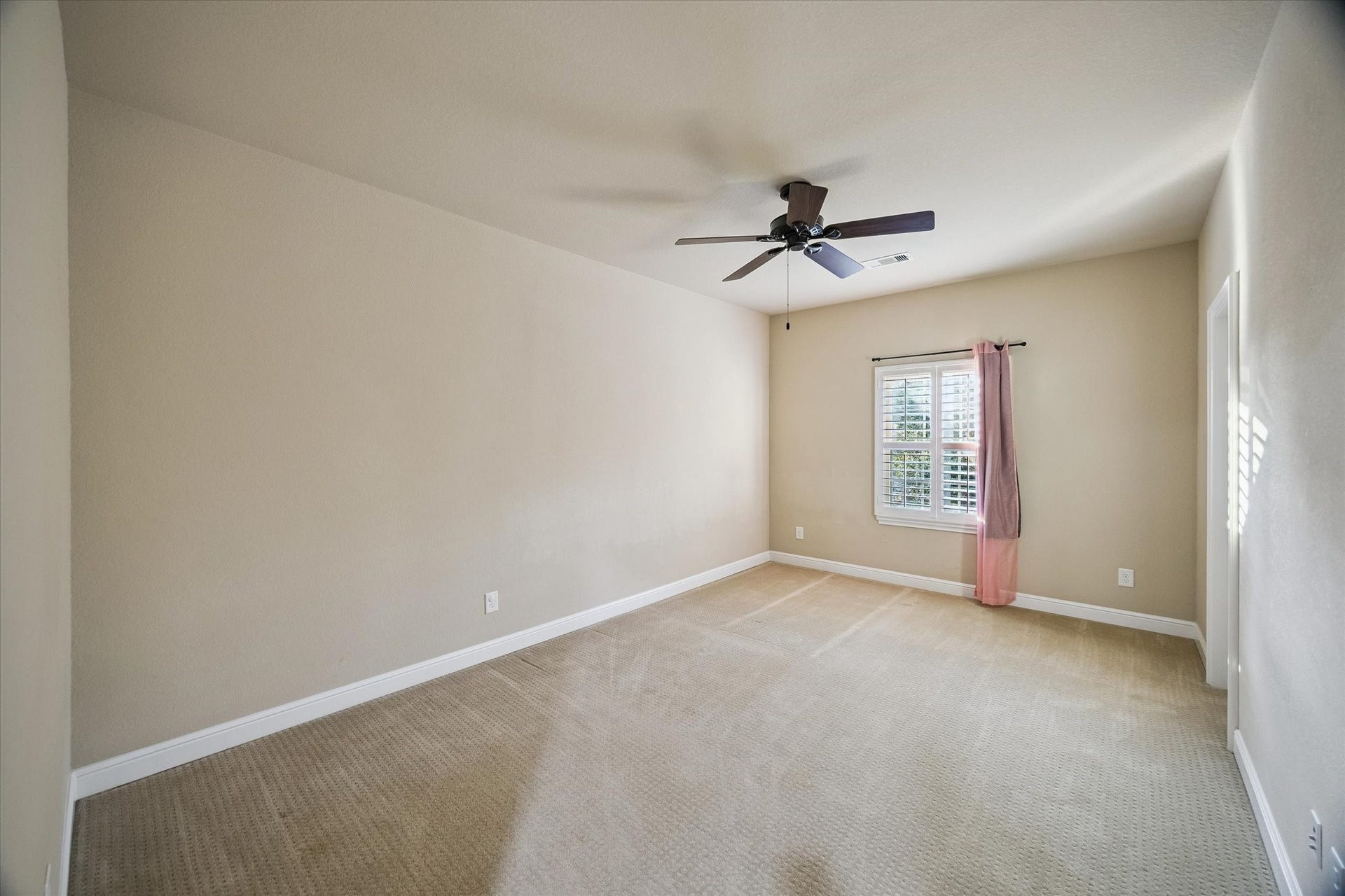 Filled with natural light and enhanced by elegant plantation shutters, this generously sized secondary bedroom offers comfort, versatility, and ample space to accommodate a variety of lifestyles and needs.