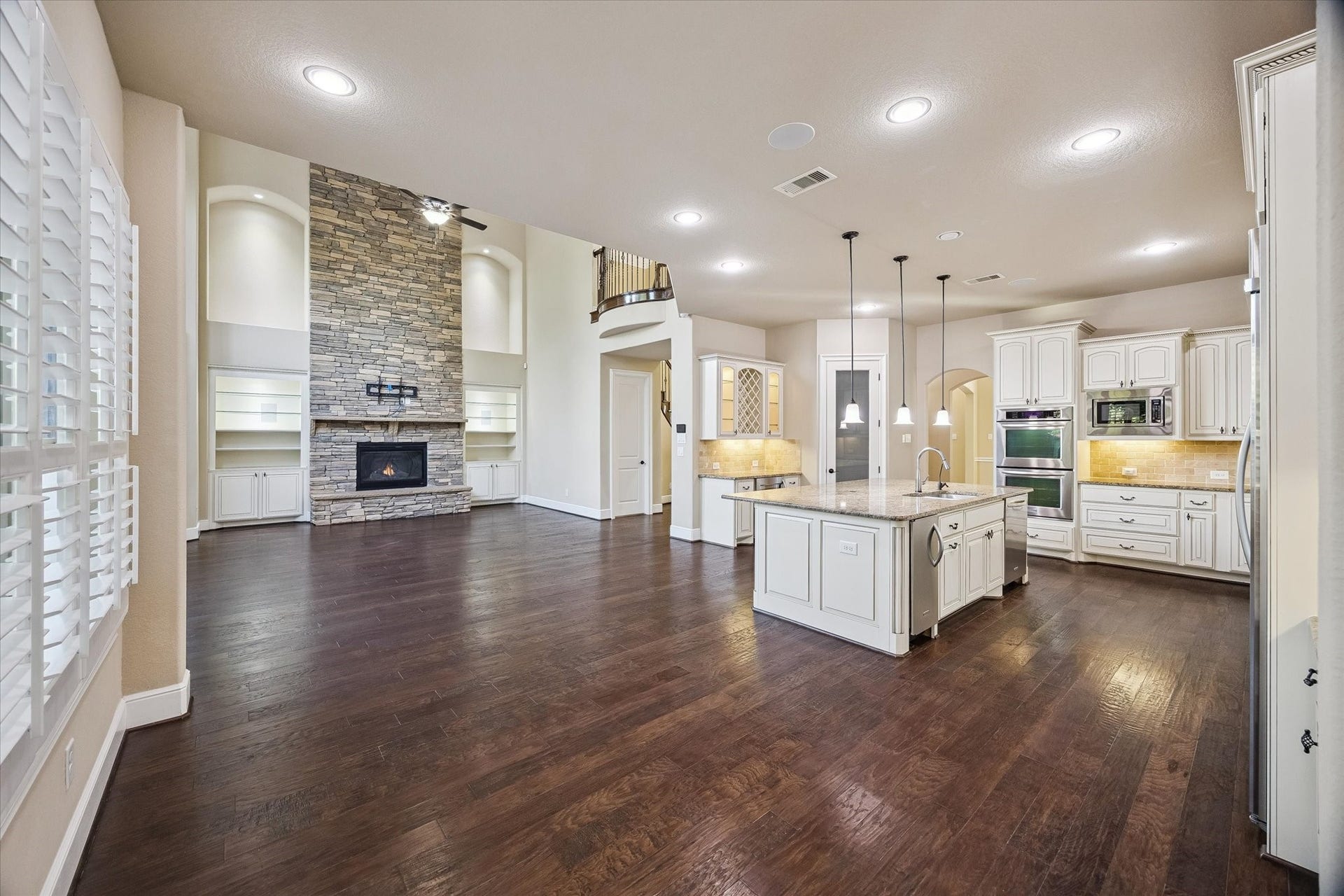 The thoughtfully designed open-concept floor plan creates a seamless flow between the kitchen, breakfast area, and family room. A stunning floor-to-ceiling stone fireplace serves as the focal point, while the walk-in pantry and butler's pantry enhance both functionality and entertaining.