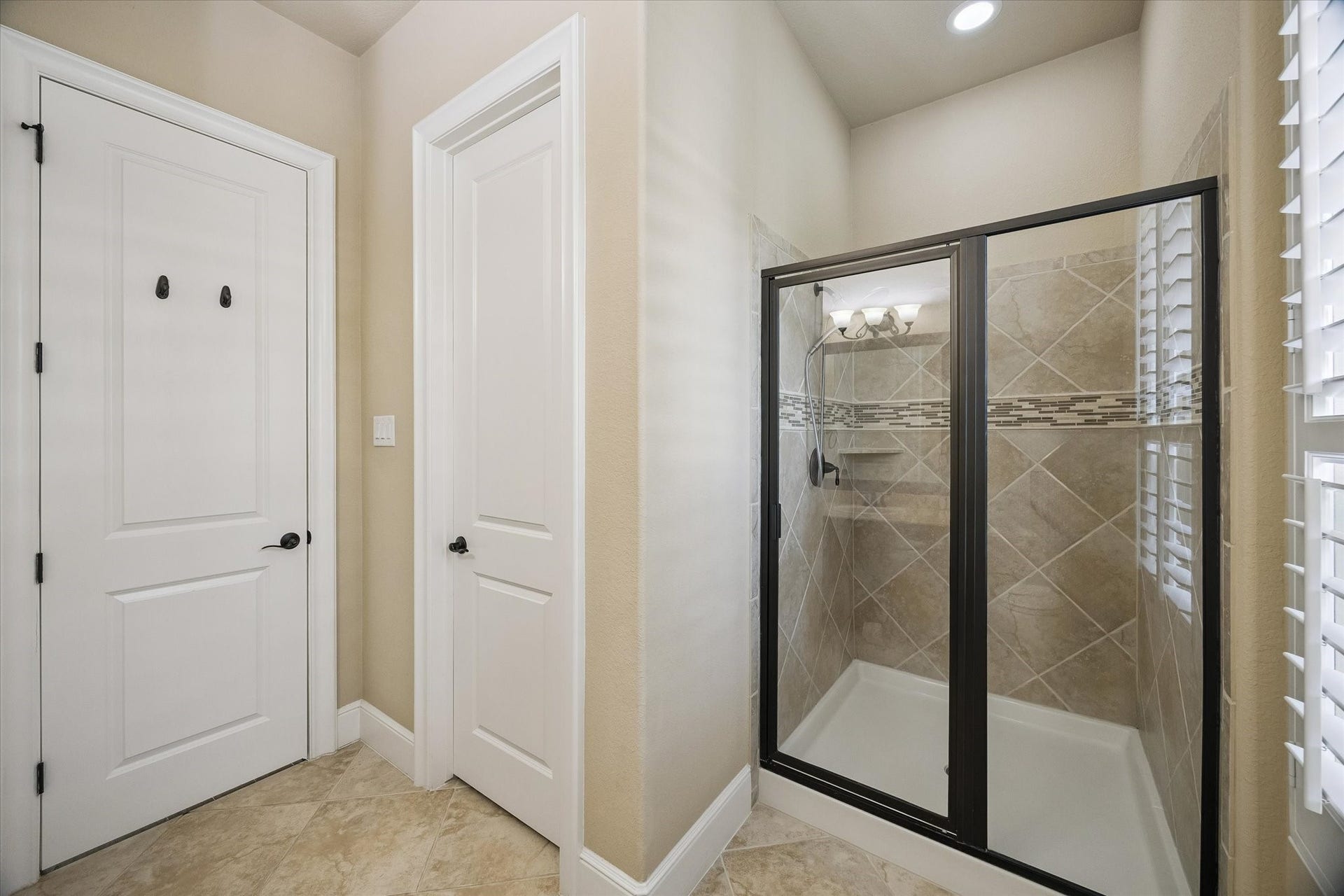 Complementing the guest suite, this private bath features a spacious walk-in shower and convenient access to a generously sized closet, enhancing both comfort and functionality.