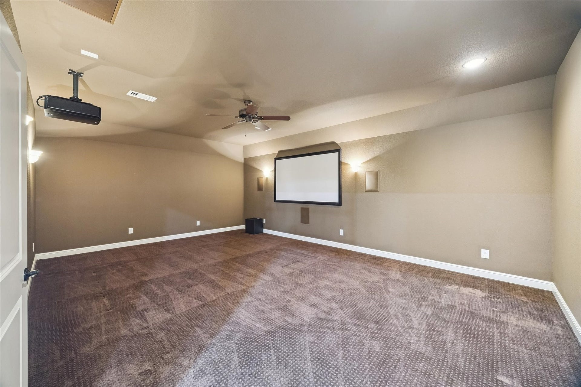 Enjoy a private theater experience from the comfort of home in this expansive media room, featuring a projection screen, projector, and abundant space for multiple seating arrangements. Whether hosting movie nights, watching the big game, or gaming with friends, this versatile space is designed for memorable entertainment.