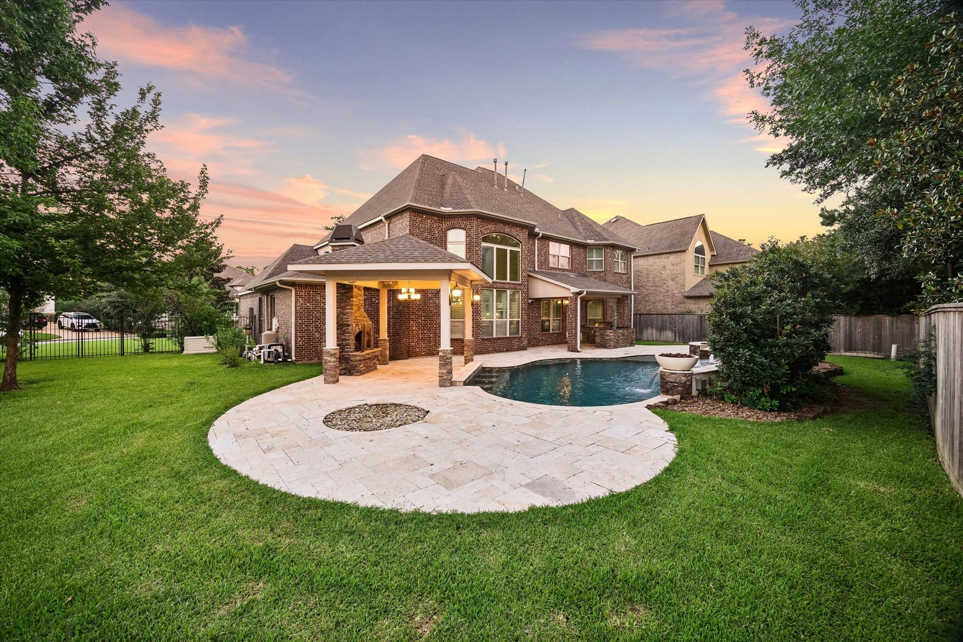 From this vantage point, the backyard unfolds as a true private retreat, featuring a resort-inspired pool and spa, expansive travertine decking, manicured lawn, and covered outdoor living spaces. The seamless connection between indoor and outdoor living creates an exceptional environment for entertaining and everyday enjoyment.