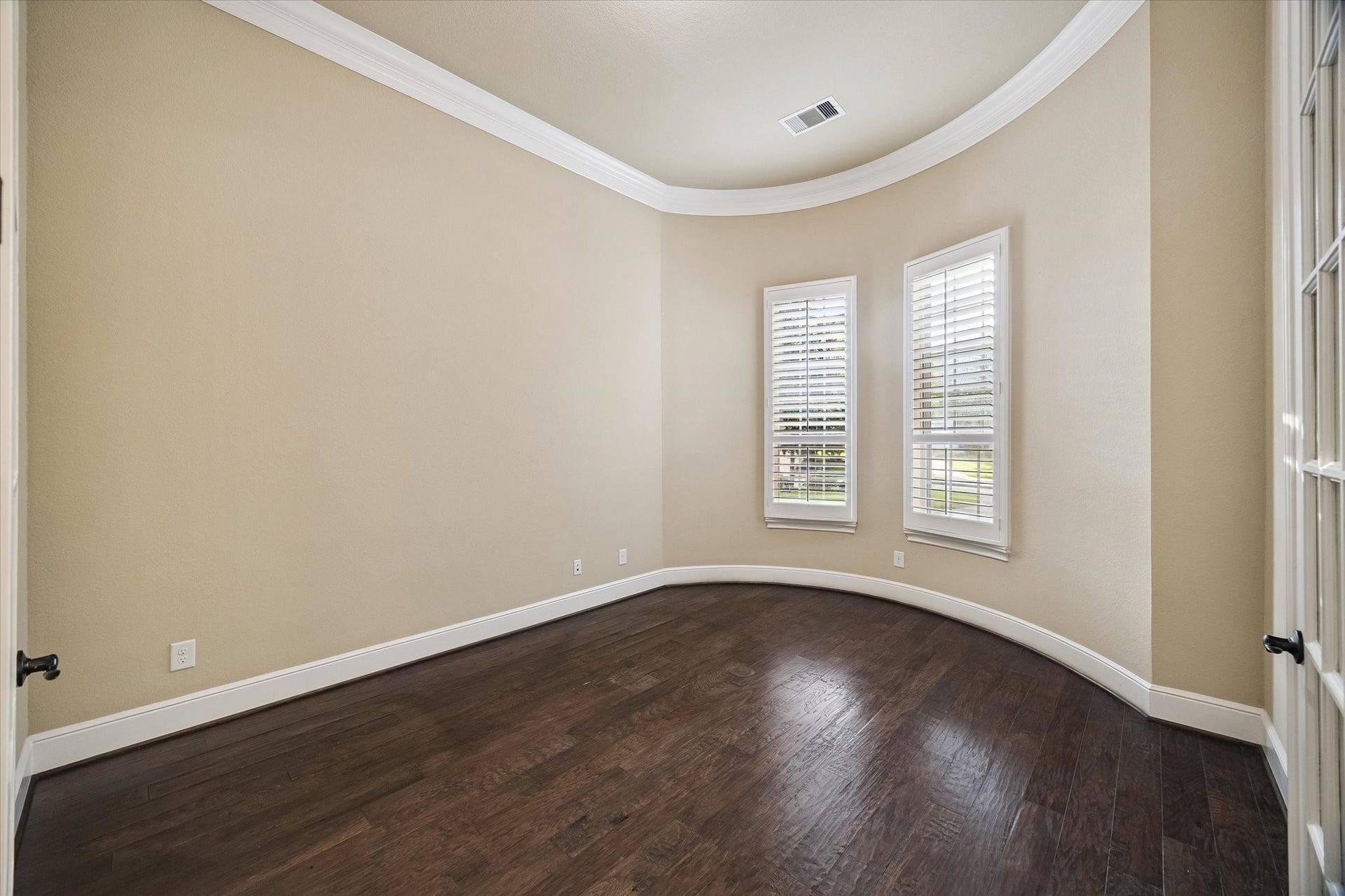 Conveniently positioned near the front of the home, this spacious study features elegant French doors, crown molding, rich hardwood flooring, and abundant natural light, creating an ideal setting for a home office or library.
