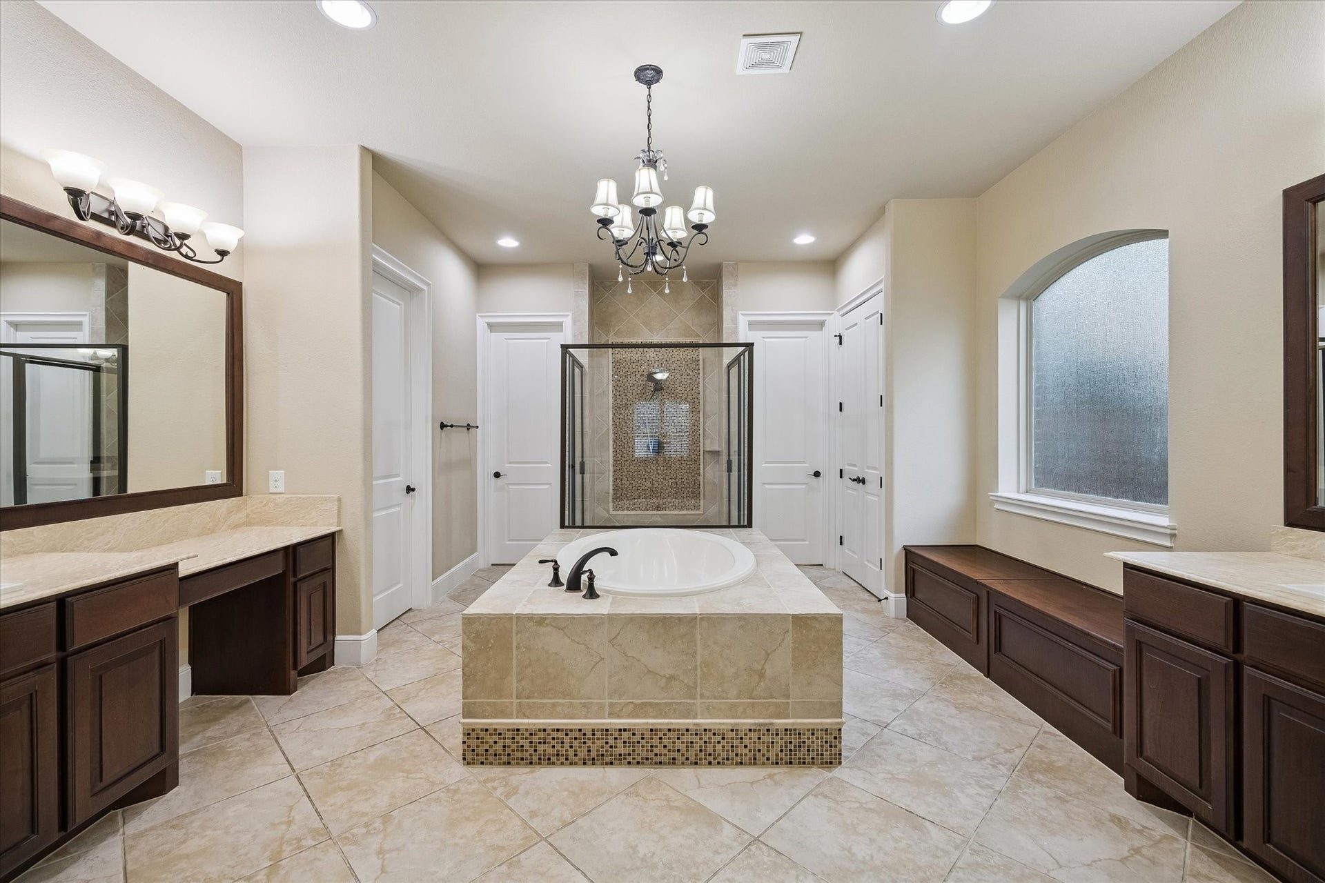 The spacious primary en-suite is designed to impress, featuring separate vanities, a relaxing soaking tub, an oversized walk-in shower, extensive storage, and elegant finishes throughout, creating a luxurious spa-inspired retreat.