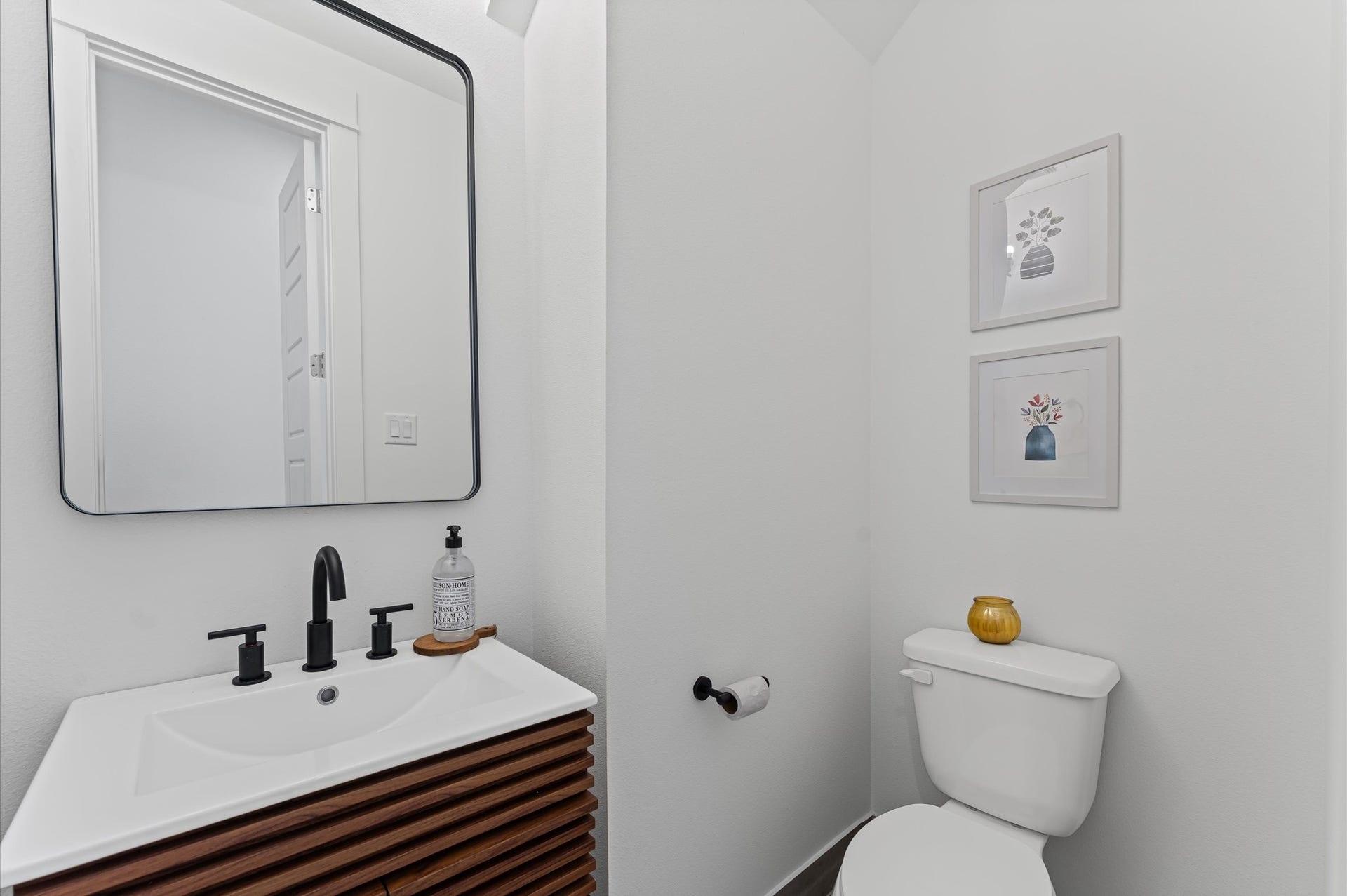 412 Neyland Street, #G, Houston, TX 77022 Tucked conveniently near the living area, this powder room blends accessibility with sleek contemporary style. Clean lines and modern fixtures define the space, from the minimalist vanity to the streamlined sink and faucet.