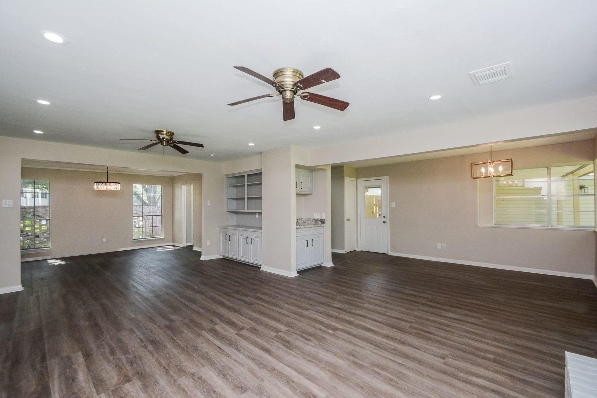 3018 Apple Valley Lane, Missouri City, TX 77459 This 1973 gem offers sheer open space in this view of combined living/dining space. High ceilings and shining rustic-like floors are complemented by soothing neutral toned walls. Note the handy wer bar, and built-in storage.