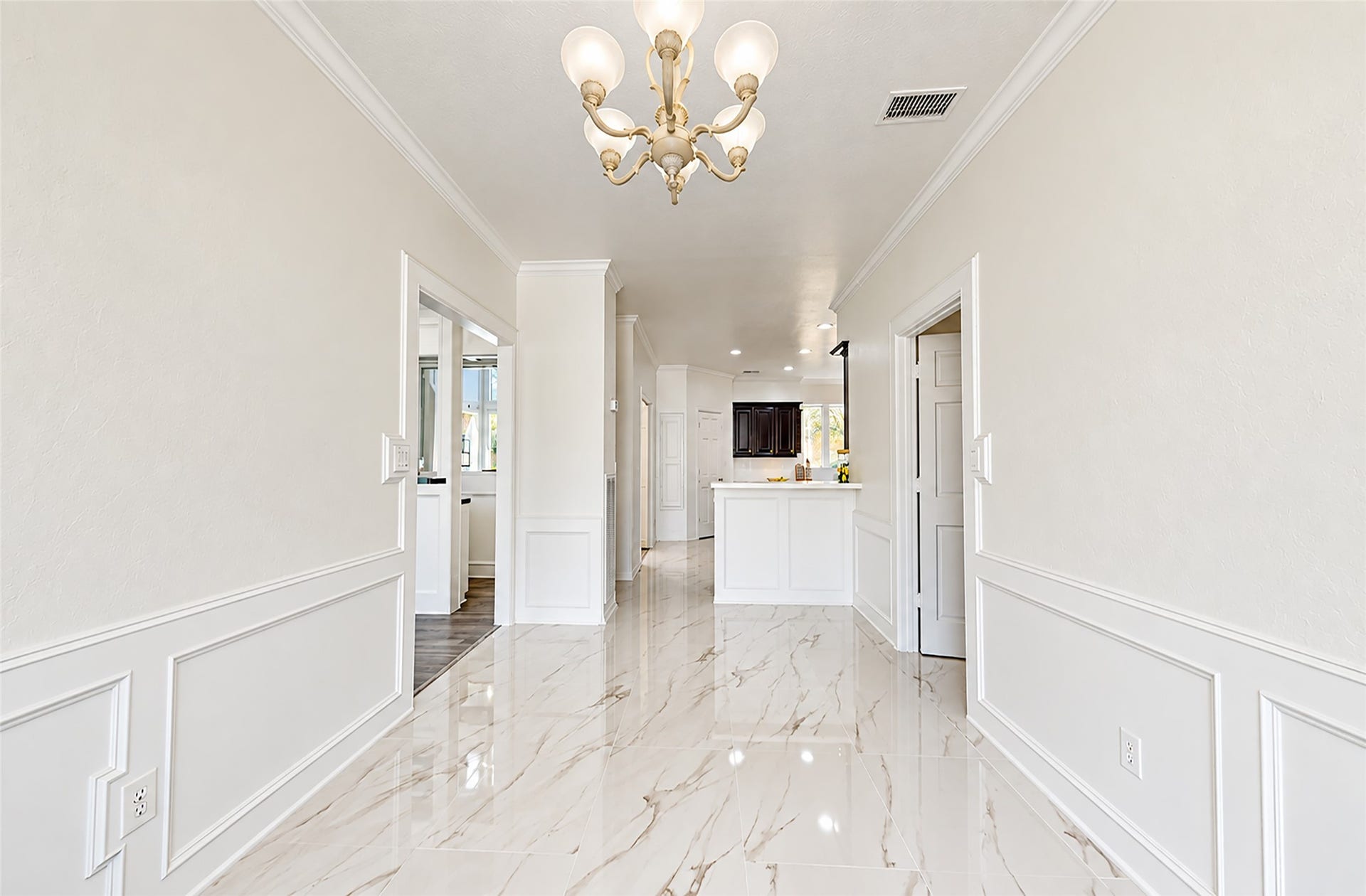 1407 Sherfield Ridge Drive, Katy, TX 77450 1407 Sherfield Ridge Dr, Bright, elegant entry and Breakfast area featuring glossy marble-look tile flooring, decorative picture-frame wall molding/wainscoting, crown molding, and a classic chandelier.