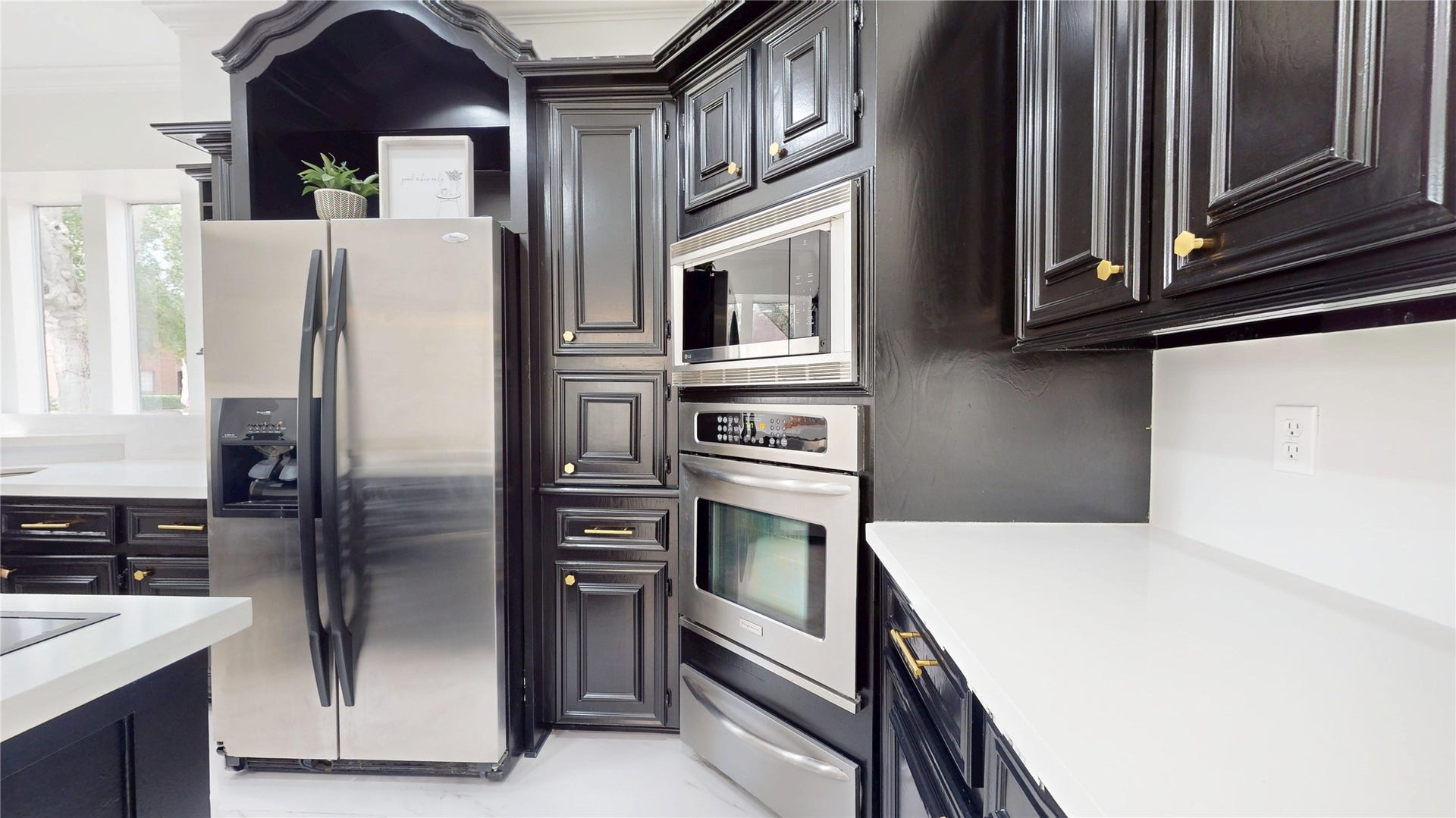1407 Sherfield Ridge Drive, Katy, TX 77450 1407 Sherfield Ridge Dr, Beautifully updated kitchen featuring dark cabinetry, bright quartz countertops, and stainless steel appliances.