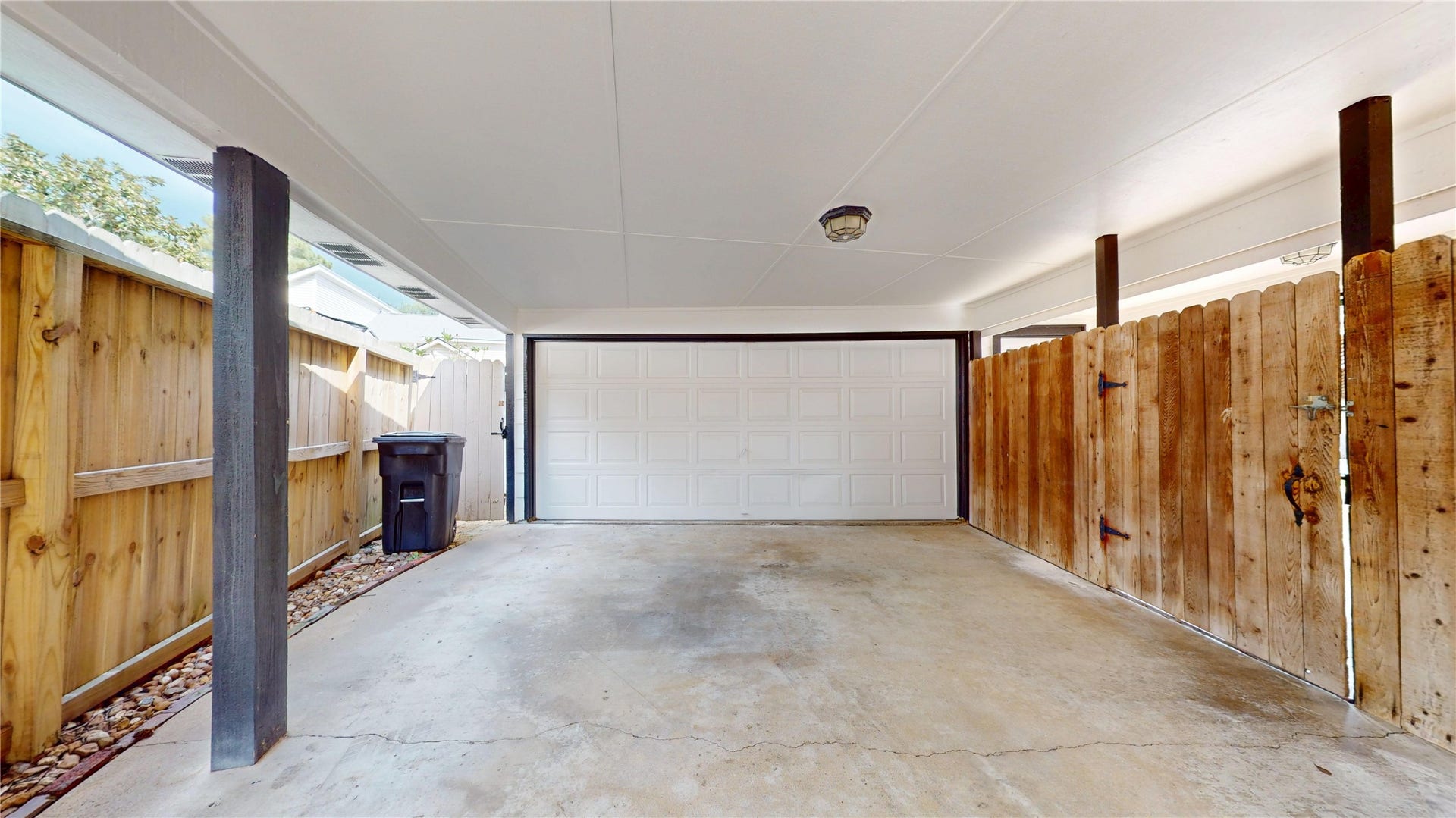 1407 Sherfield Ridge Drive, Katy, TX 77450 1407 Sherfield Ridge Dr, Spacious covered carport with a concrete driveway, privacy fencing, gated access, and overhead lighting. The covered area provides convenient protected parking with easy access to the property.