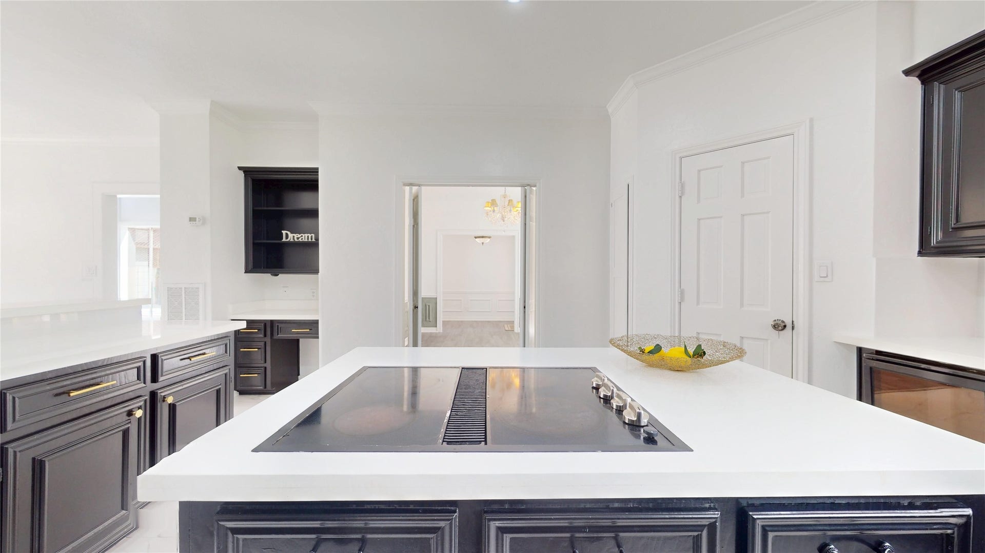 1407 Sherfield Ridge Drive, Katy, TX 77450 1407 Sherfield Ridge Dr, Updated kitchen with dark abundant cabinetry, and a large center island with cooktop with pantry door and entrance to formal dining area.
