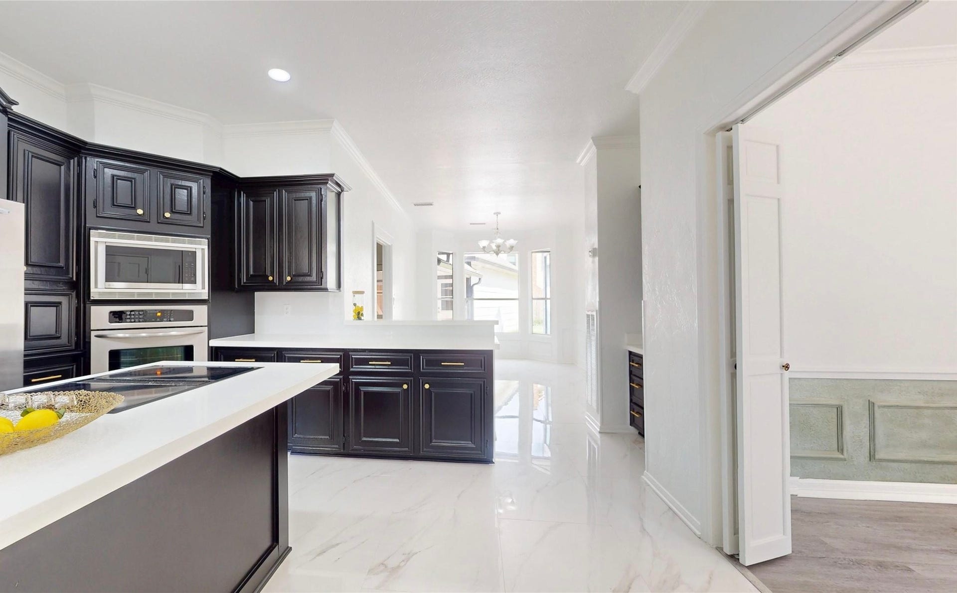 1407 Sherfield Ridge Drive, Katy, TX 77450 1407 Sherfield Ridge Dr, Updated kitchen with dark cabinetry excellent for storage, bright quartz countertops, white marble flooring and stainless steel appliances. A large center island with cooktop facing the Breakfast area and walkway on the right to the formal dining area.