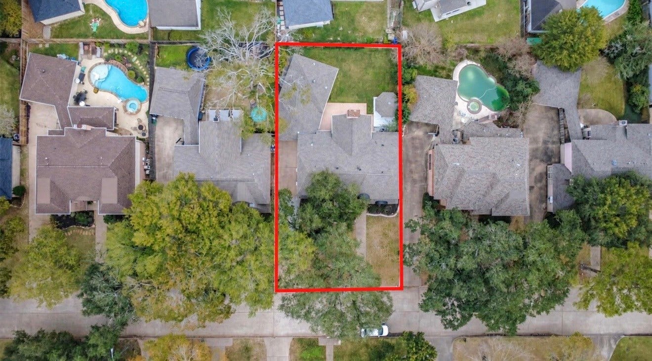 1407 Sherfield Ridge Drive, Katy, TX 77450 1407 Sherfield Ridge Dr, Aerial view highlighting the property boundaries in red. The home sits on a spacious lot with a large backyard, mature trees, and an extended driveway, surrounded by established neighboring homes. The generous outdoor space offers plenty of room for entertaining, gardening, or future outdoor improvements.