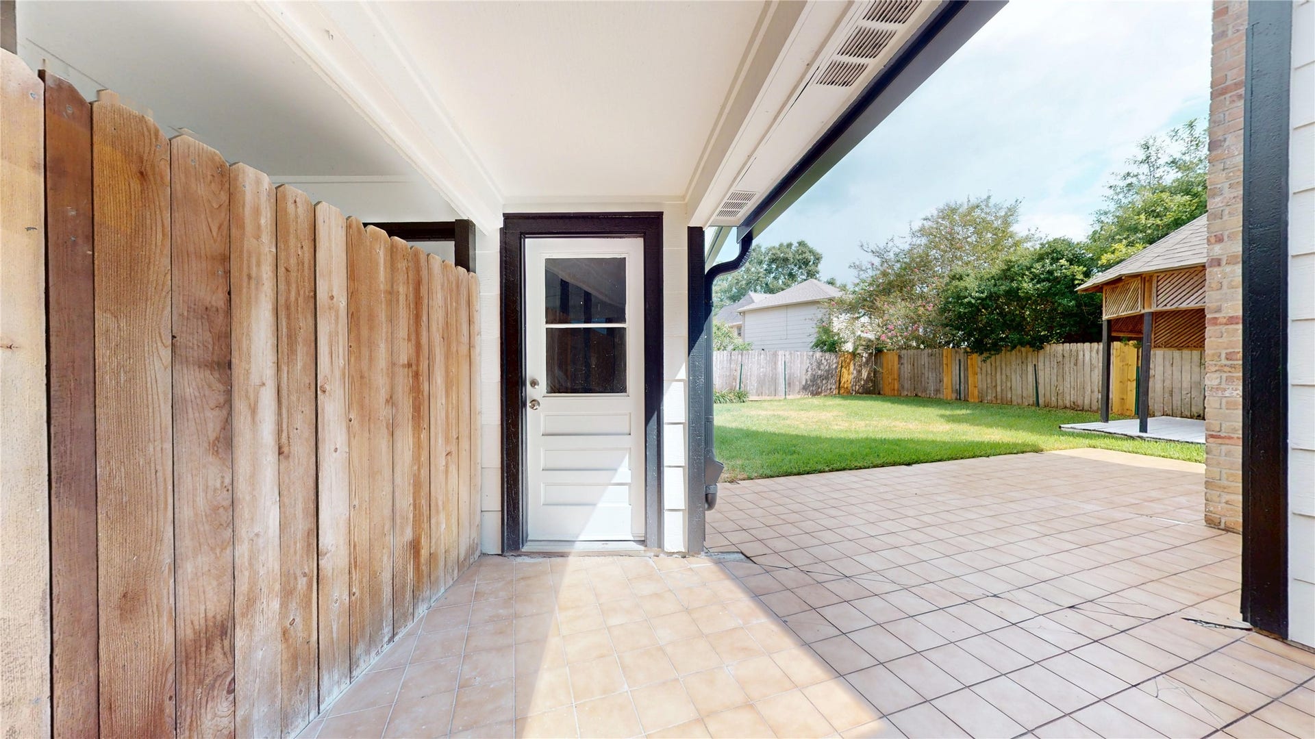 1407 Sherfield Ridge Drive, Katy, TX 77450 1407 Sherfield Ridge Dr, Spacious covered back patio featuring a tiled surface, door to garage. The extended patio provides plenty of room for outdoor seating and entertaining, with easy access to the large, fully fenced backyard and mature landscaping.