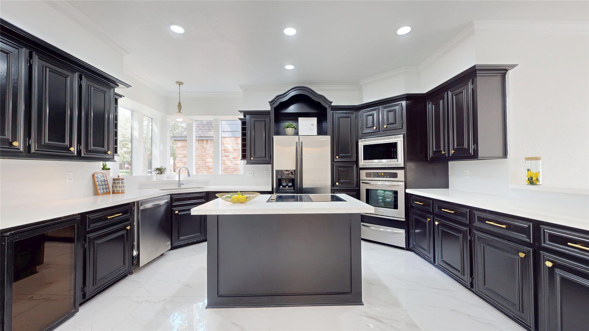 1407 Sherfield Ridge Drive, Katy, TX 77450 1407 Sherfield Ridge Dr, Spacious, beautifully updated kitchen featuring dark abundant cabinetry excellent for storage, bright quartz countertops, white marble flooring and stainless steel appliances. A large center island with cooktop provides aditonal prep and gathering space.