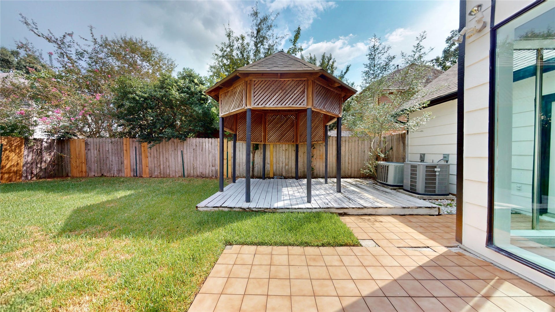 1407 Sherfield Ridge Drive, Katy, TX 77450 1407 Sherfield Ridge Dr, Spacious backyard featuring a wooden gazebo with a raised deck, a paver patio, and plenty of green lawn space. The fully fenced yard offers privacy and provides a great setting for outdoor entertaining, relaxing, or gatherings.