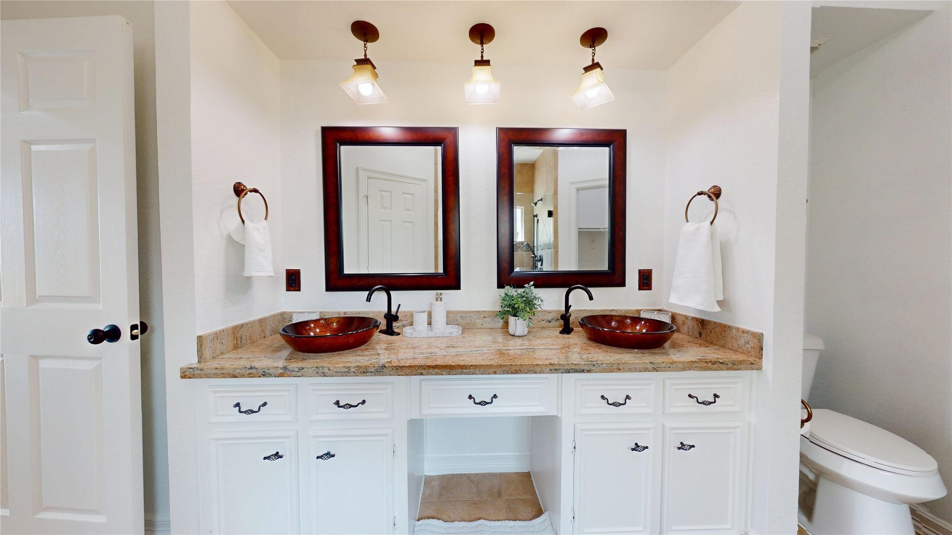 1407 Sherfield Ridge Drive, Katy, TX 77450 1407 Sherfield Ridge Dr, Spacious primary bathroom featuring a long dual-sink vanity with granite countertops, decorative vessel sinks, and large framed mirrors.