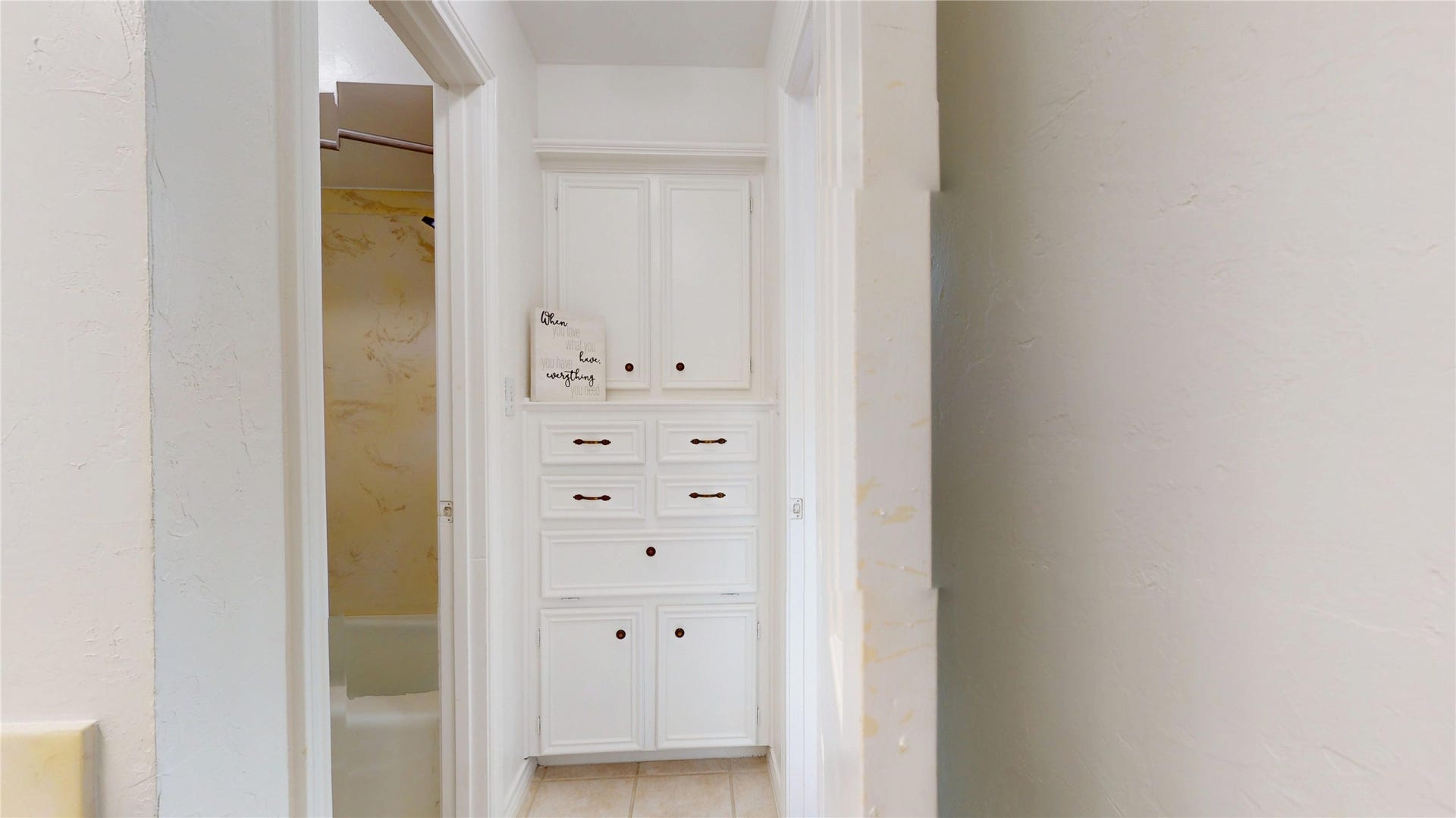 1407 Sherfield Ridge Drive, Katy, TX 77450 1407 Sherfield Ridge Dr, Jack and jill 3rd bathroom on 2nd floor with white cabinetry for storage.