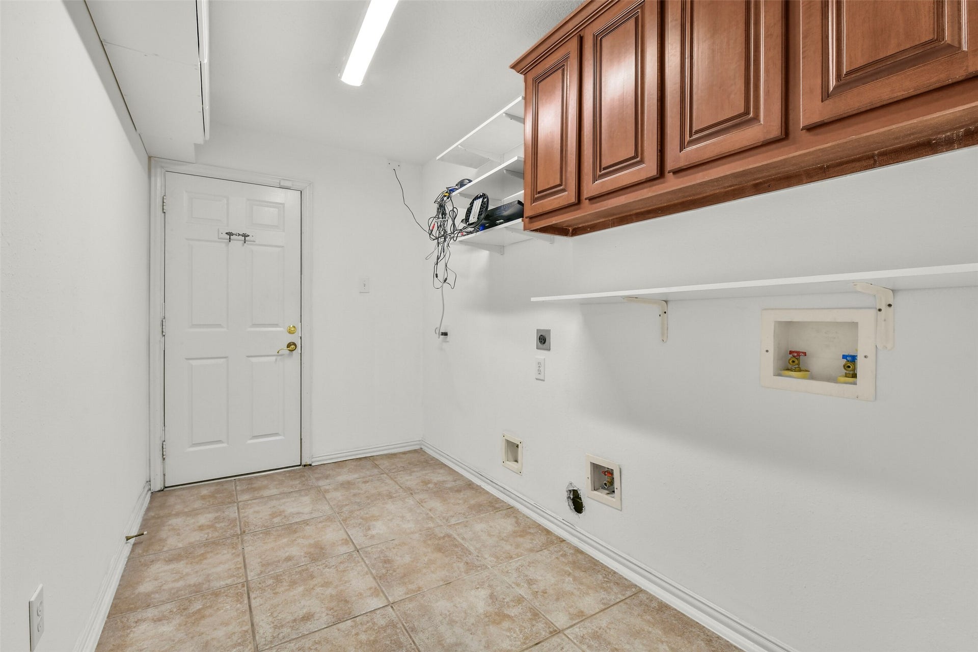 9902 Autumn Lake Trail, Pearland, TX 77584 Spacious utility room featuring ample cabinet storage, tile flooring, and convenient hookups for laundry appliances.