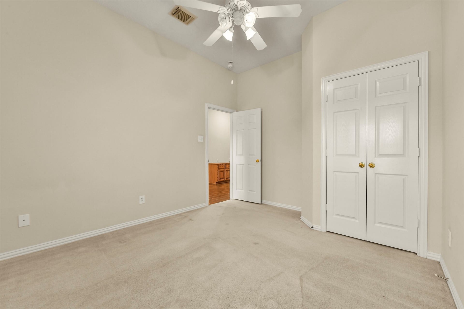 9902 Autumn Lake Trail, Pearland, TX 77584 Bright and inviting room with neutral walls, plush carpet, a ceiling fan, and a spacious closet with double doors.