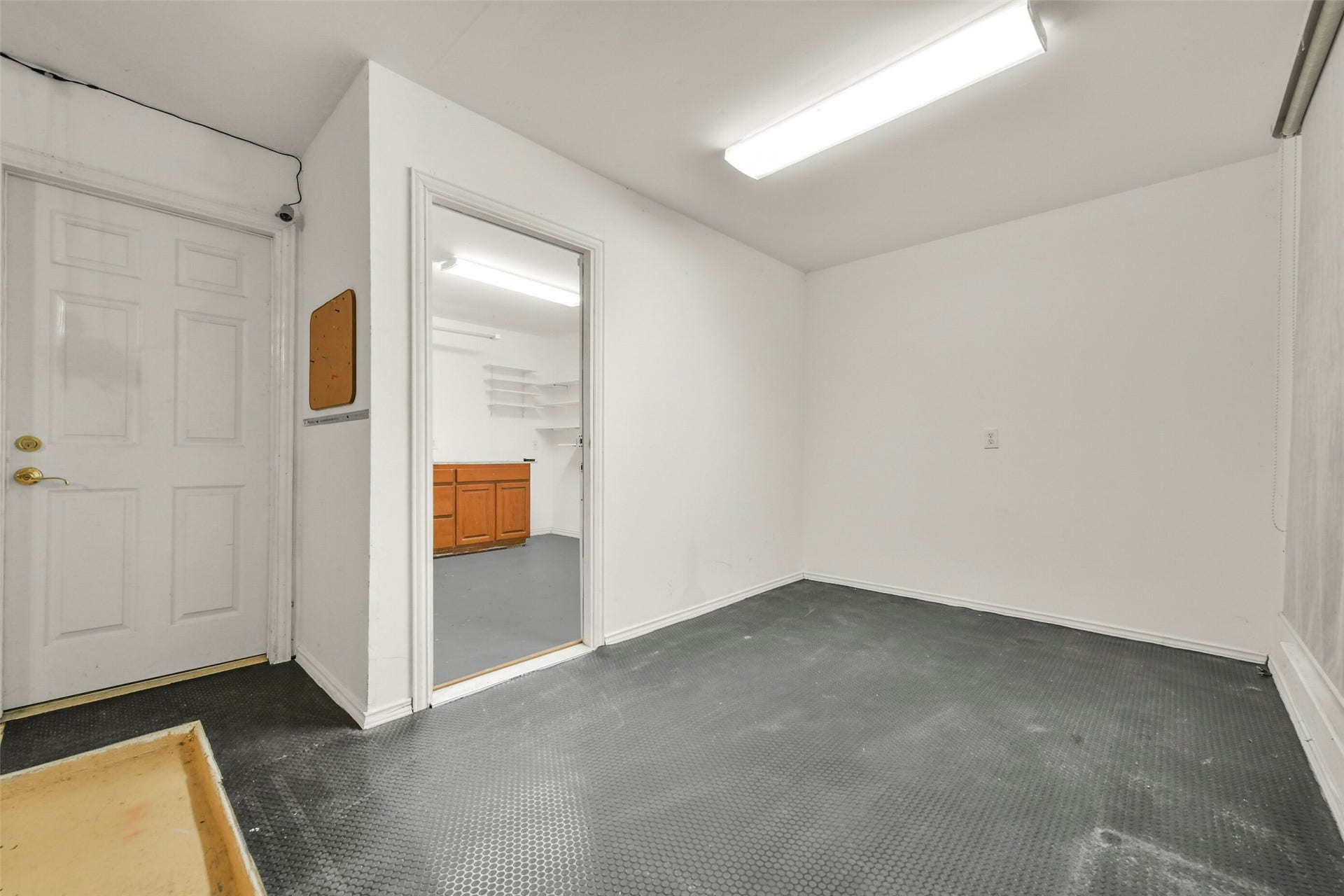 9902 Autumn Lake Trail, Pearland, TX 77584 Spacious and versatile room in garage featuring durable flooring, bright lighting, and access to an adjacent area with shelving and cabinetry. Woodshop is air conditioned as well.