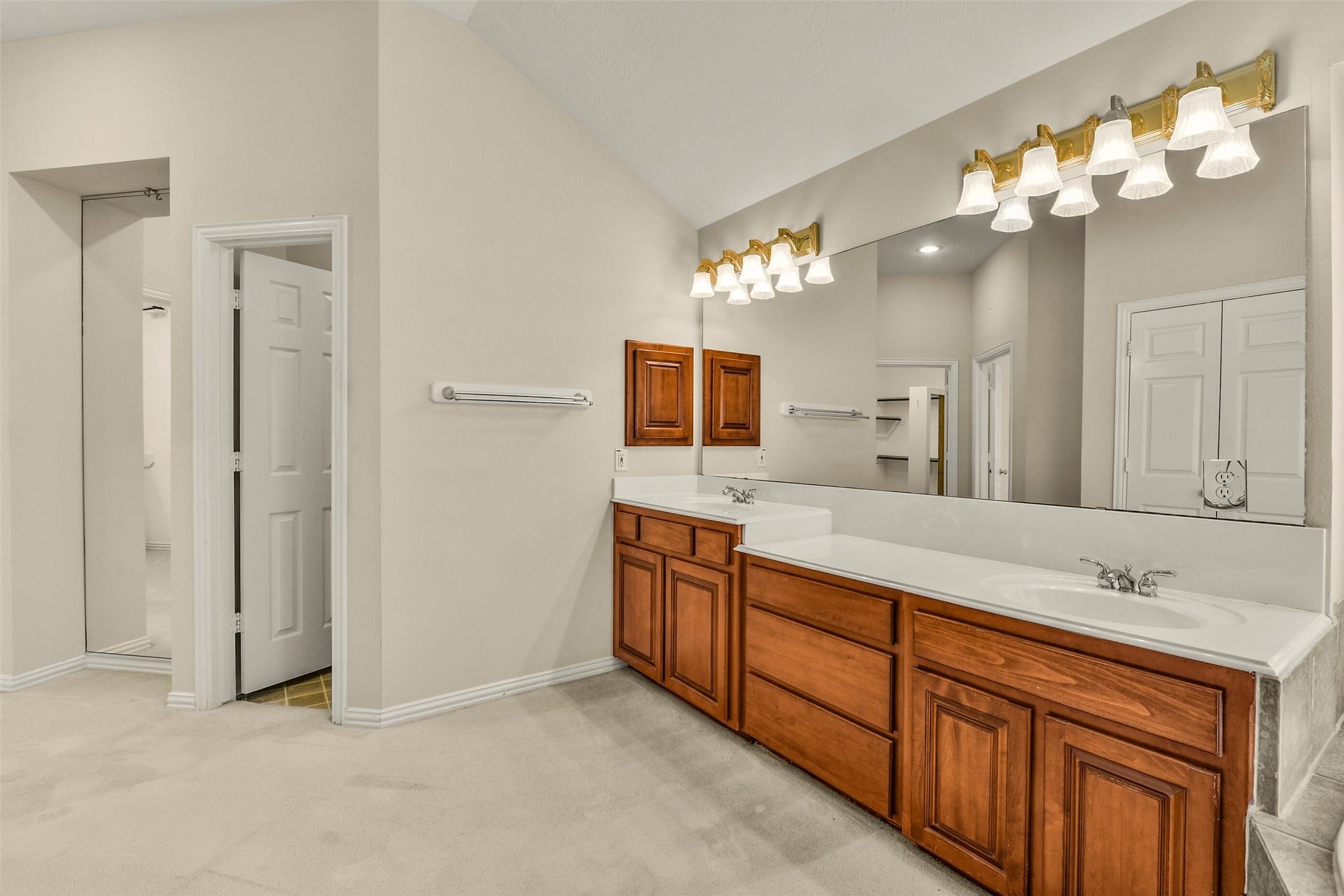 9902 Autumn Lake Trail, Pearland, TX 77584 Spacious bathroom featuring a double vanity with elegant wood cabinetry, large mirrors, and ample lighting, offering a bright and functional space.