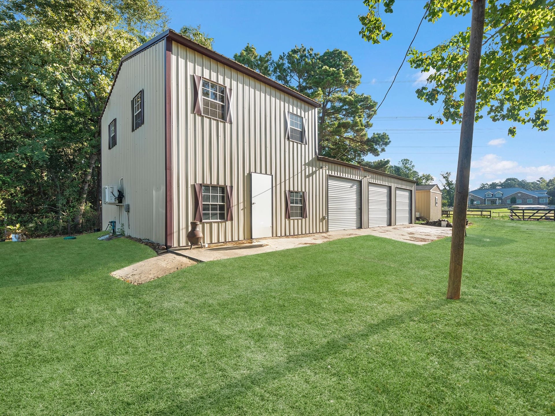 32403 Dobbin Huffsmith Road, Magnolia, TX 77354 Driveway leading to Structures 1 and 2. Structure 1 features a spacious 3-car garage with a 1-bedroom, 1-bath loft above. Structure 2 offers approximately 200 sq ft with a 1-bedroom layout.