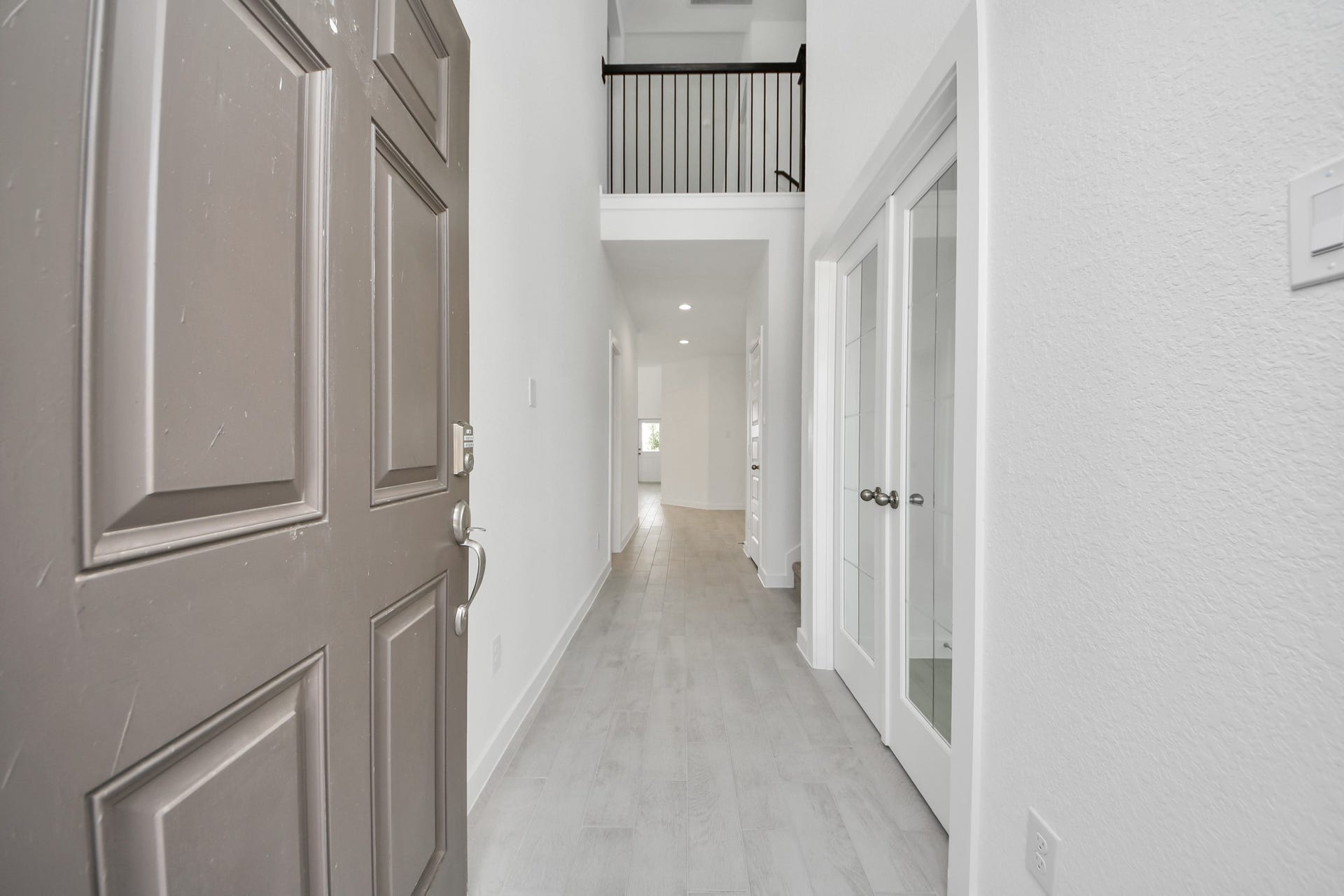 As you step into the threshold of this luxurious home, you'll soon be welcomed by an elegant glass door (to be installed). Inside, soaring ceilings amplify the spaciousness, while the refined wood-look tile flooring and oversized baseboards exude sophistication and charm. Sample photo of completed home with similar floor plan. Actual colors and selections may vary.