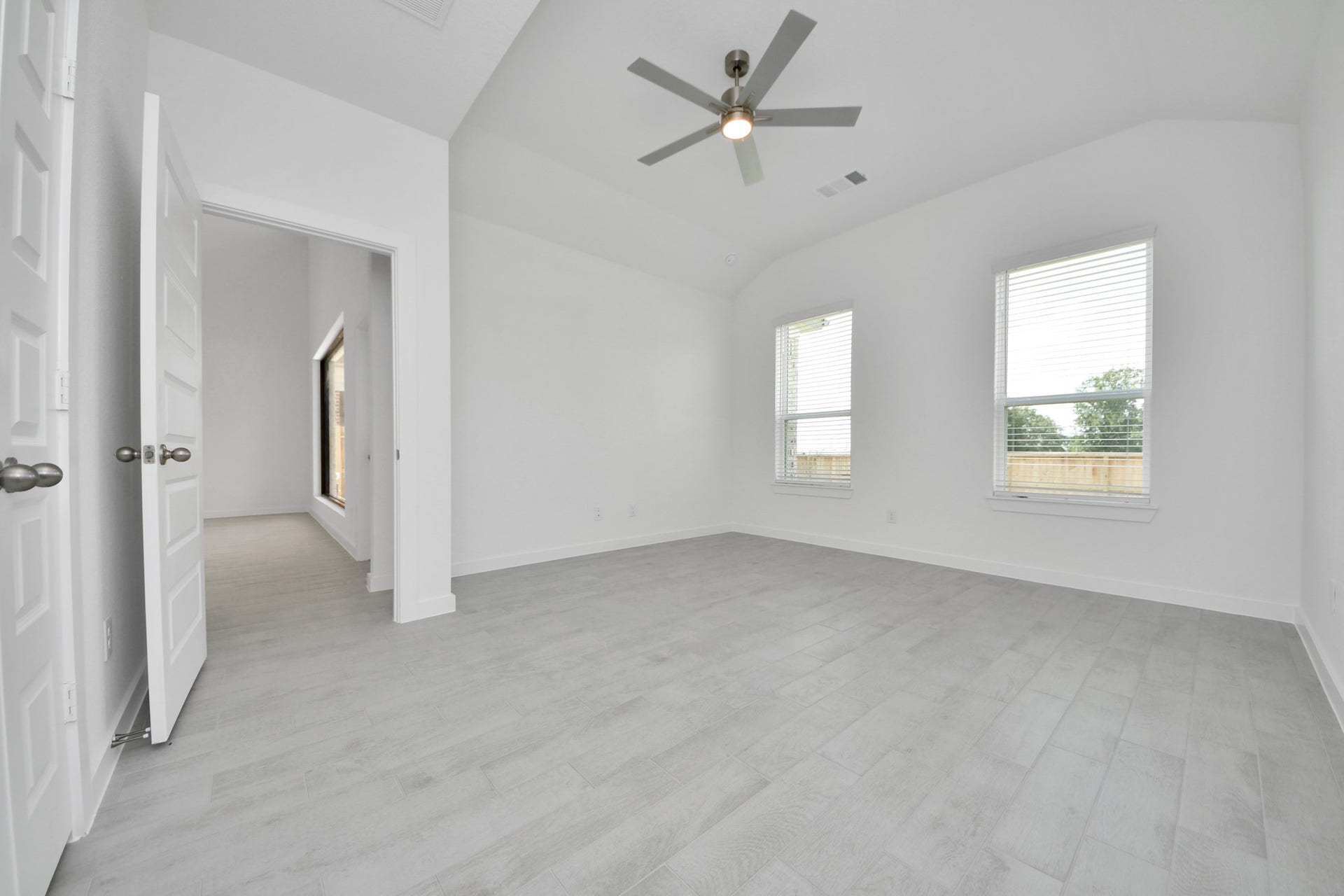 Come and unwind after a long day in this magnificent primary suite! This spacious room features warm paint, high ceilings and large windows with privacy blinds. Sample photo of completed home with similar floor plan. Actual colors and selections may vary.