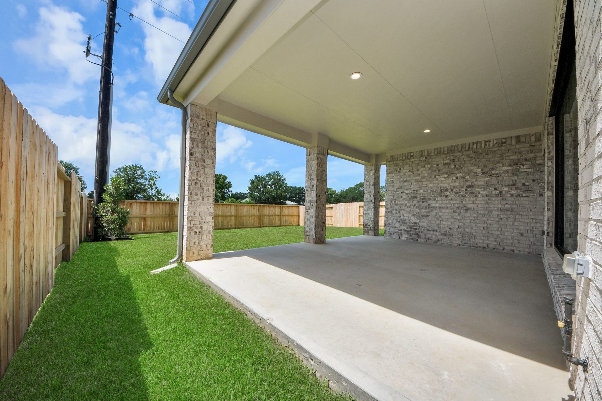Experience outdoor living at its finest on this expansive covered patio, thoughtfully designed for BBQs and delightful outdoor dining. Sample photo of completed home with similar floor plan. Actual colors and selections may vary.