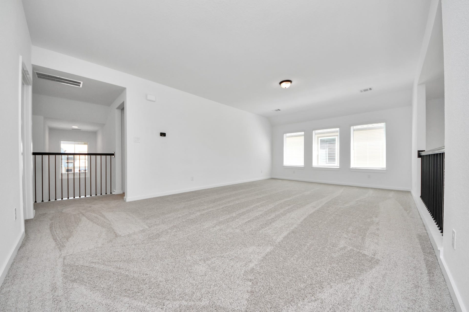 Come upstairs and enjoy a day of leisure in this fabulous game room! This is the perfect hangout spot or adult game room! Features plush carpet, high ceilings, custom paint and windows for plenty of natural light. Sample photo of completed home with similar floor plan. Actual colors and selections may vary.