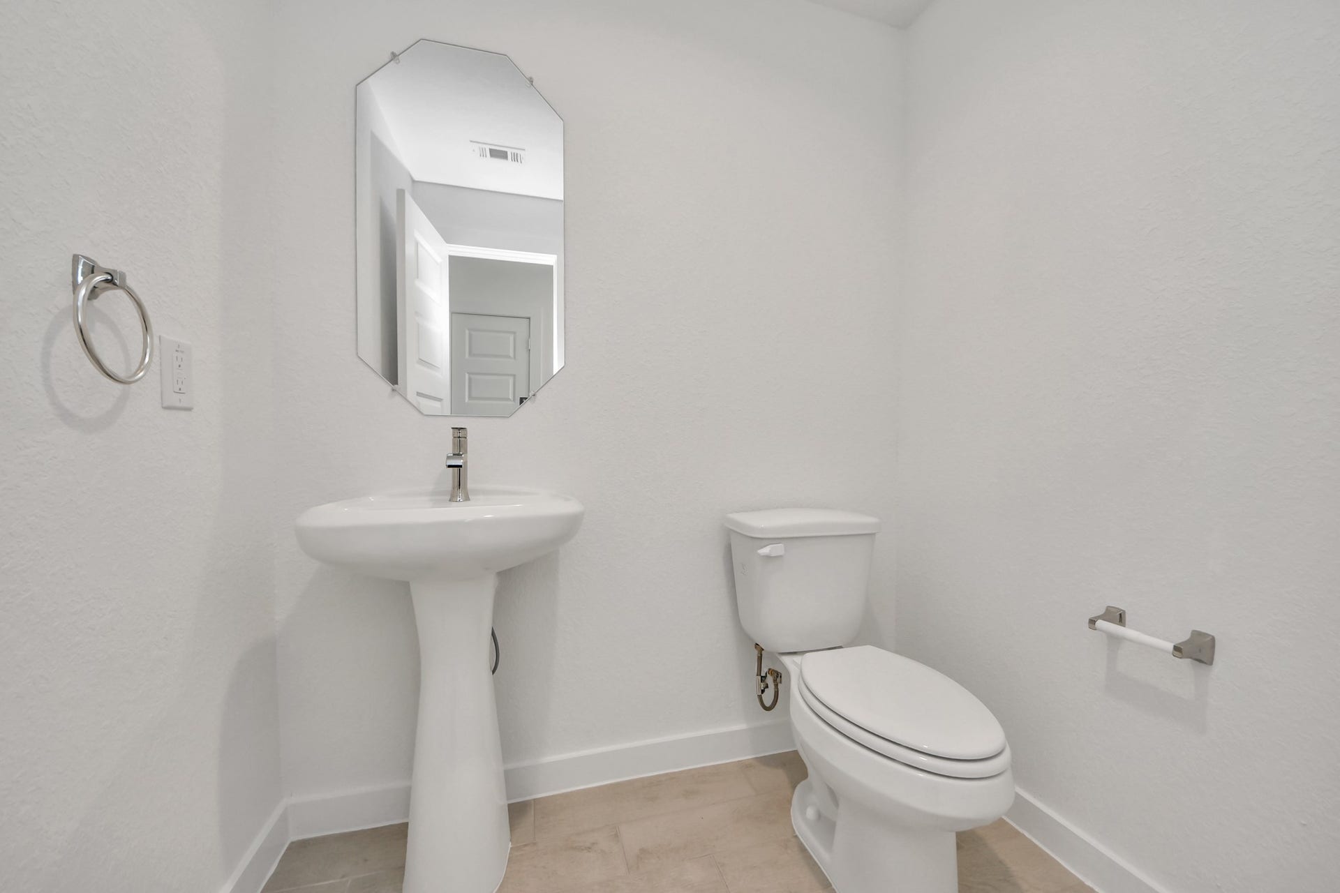 This half bathroom features a stylish pedestal sink, modern hardware, and bright recessed lighting, creating a sleek and inviting space. Sample photo of completed home with similar floor plan. Actual colors and selections may vary.