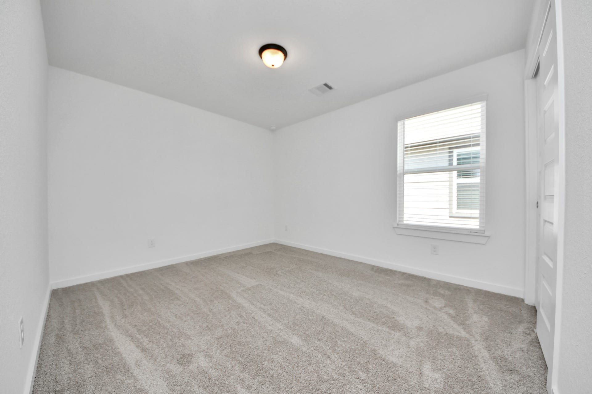 Secondary bedroom features plush carpeting, large windows that let in plenty of natural light, bright paint, and spacious closets. Sample photo of completed home with similar floor plan. Actual colors and selections may vary.