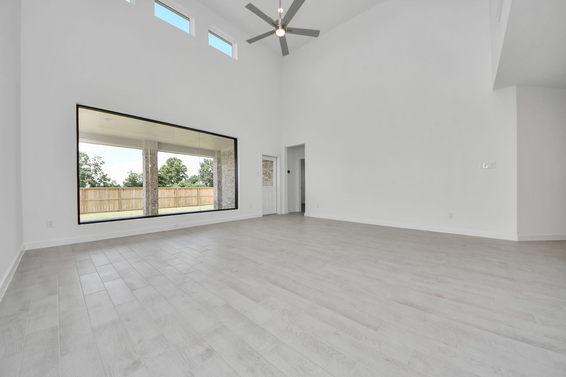 Welcome family and guests to your charming living room! With its high ceilings, recessed lighting, ceiling fan, custom paint, beautiful flooring, and large windows that let in abundant natural light, this room is perfect for gatherings. Sample photo of completed home with similar floor plan. Actual colors and selections may vary.