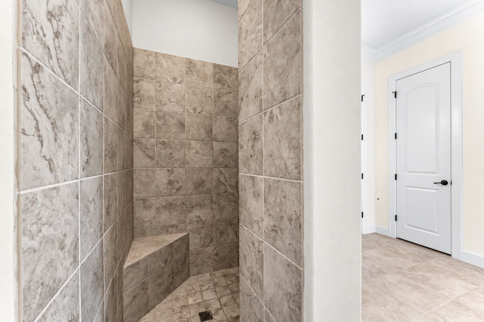 A sleek, beautifully designed primary shower is thoughtfully tucked away for added privacy