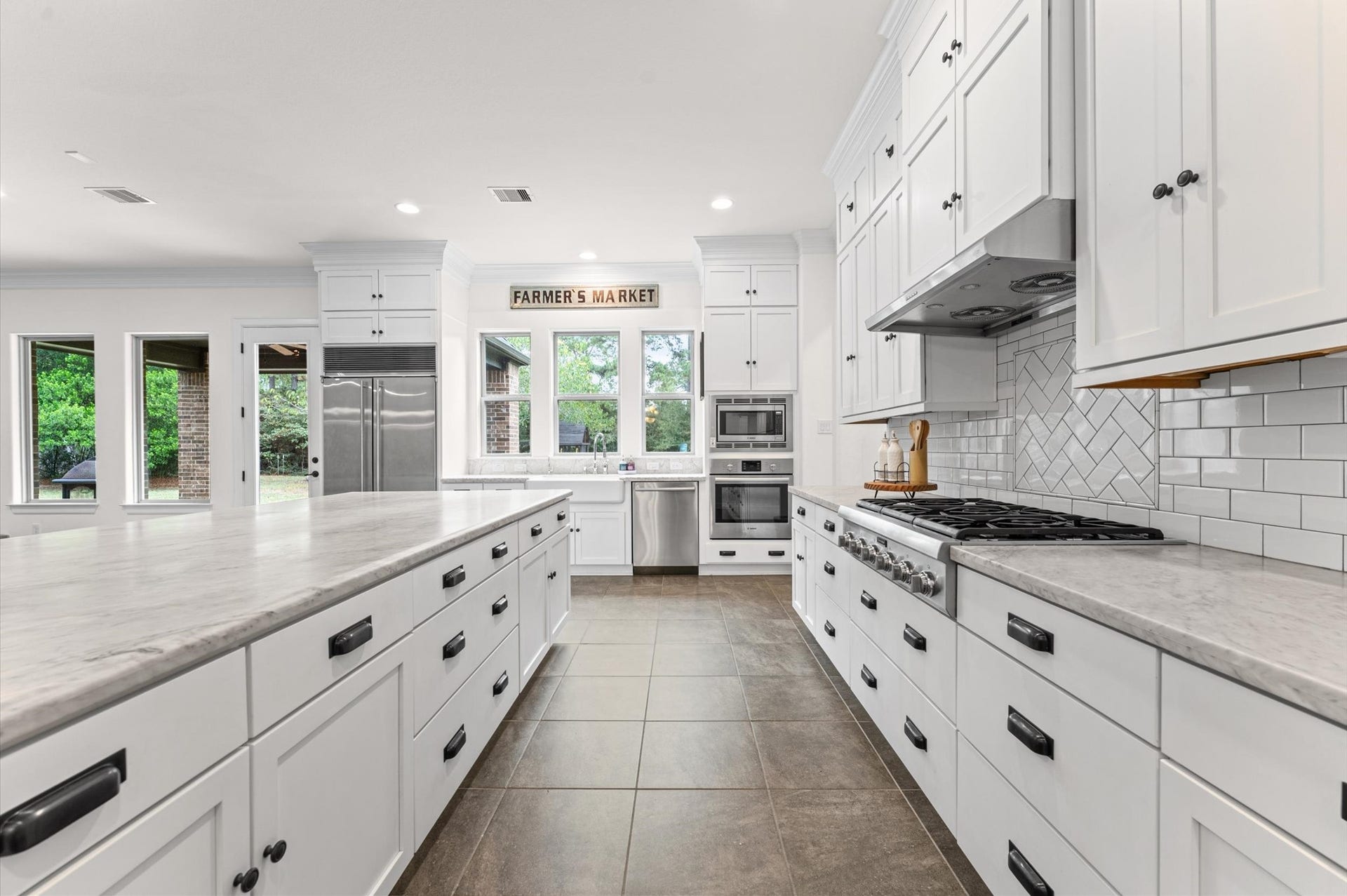 Step into this chefs dream kitchen, featuring elegant marble countertops, premium stainless steel Thermador appliances, and a spacious island free of a cooktop; perfect for meal preparation and entertaining. Beautiful inset cabinetry and a generous walk-in pantry provide both style and functionality, making this kitchen as practical as it is stunning.