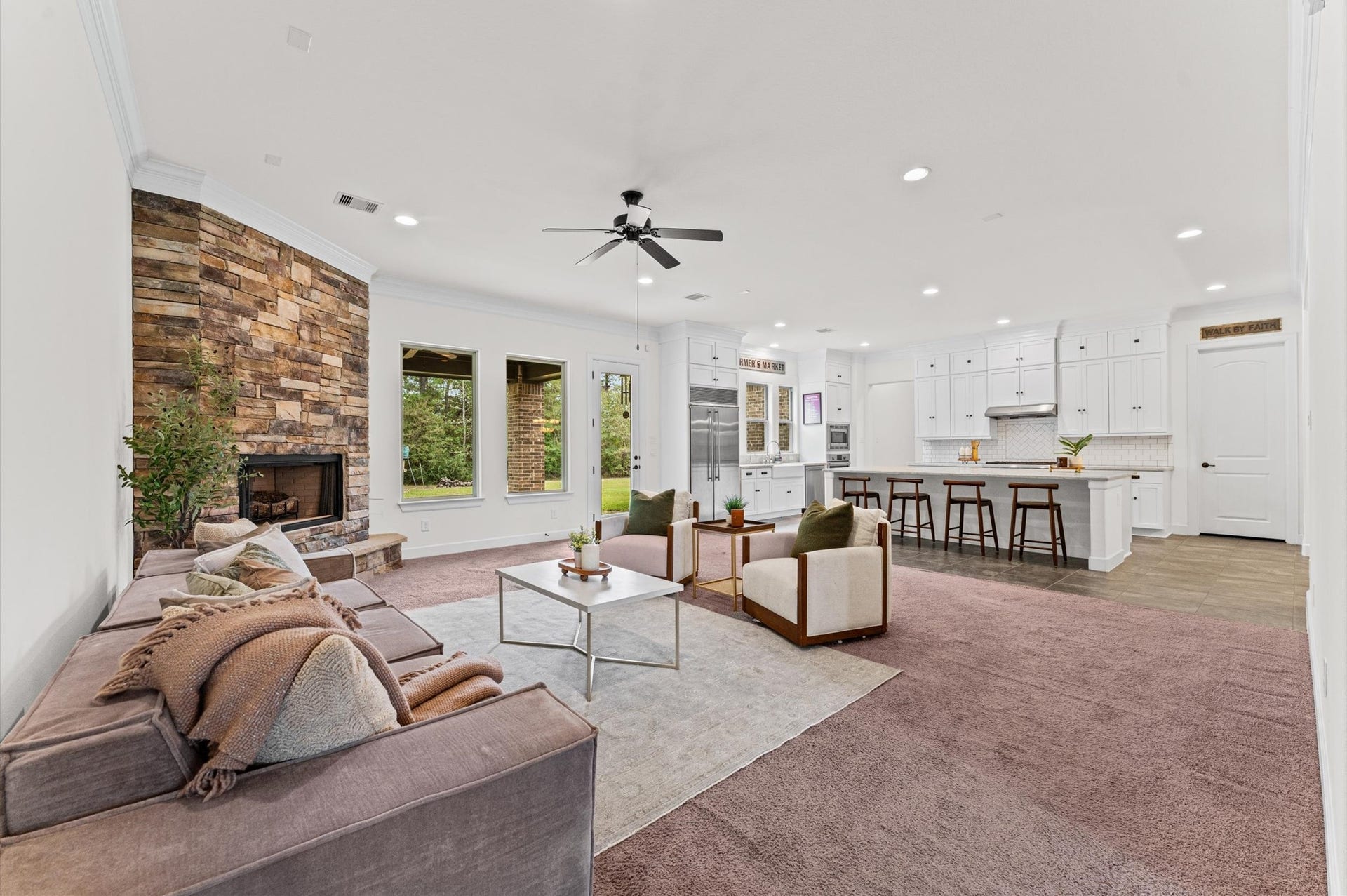 A stunning wood-burning fireplace with distinctive stone detailing serves as the centerpiece of the formal living room, adding warmth, character, and timeless elegance. Expansive windows invite an abundance of natural light, beautifully complementing the home's classic design and inviting atmosphere.