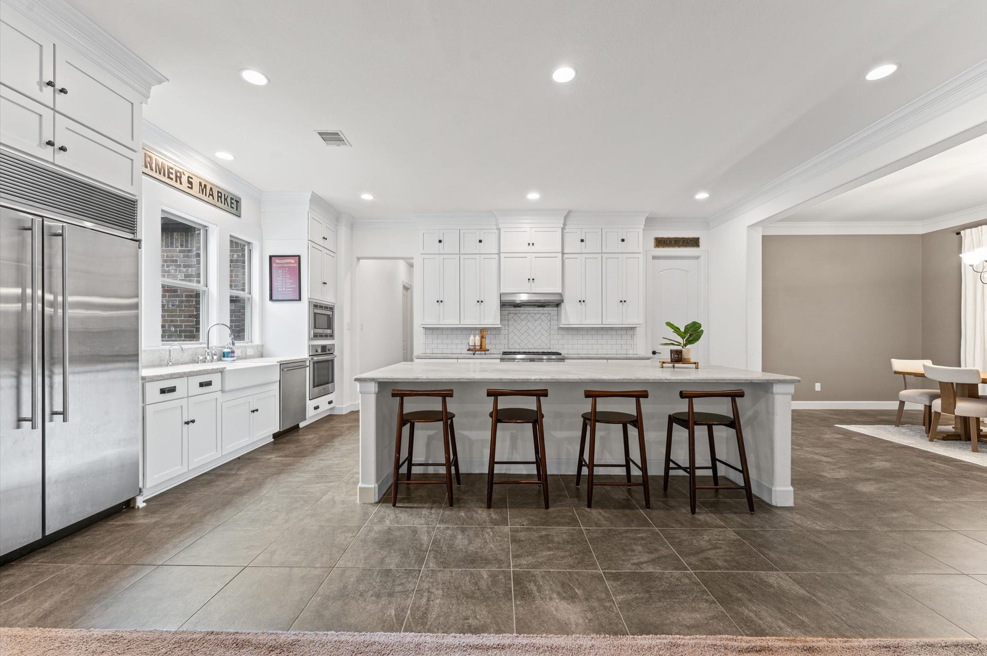 The kitchen offers an abundance of cabinetry for storage and flows seamlessly into the spacious formal dining room, creating the perfect setting for holiday celebrations, family gatherings, and entertaining guests.