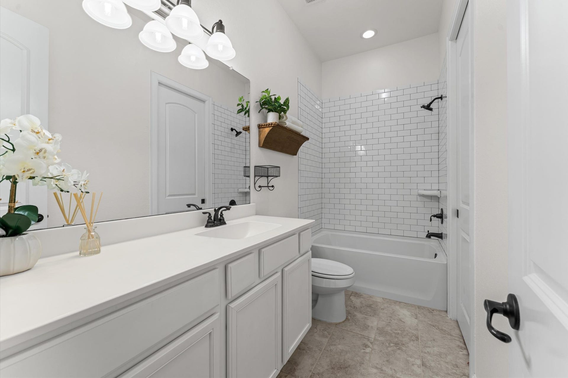The third full bathroom features expansive countertop space and beautiful tile backsplash detailing, combining timeless style with everyday functionality!