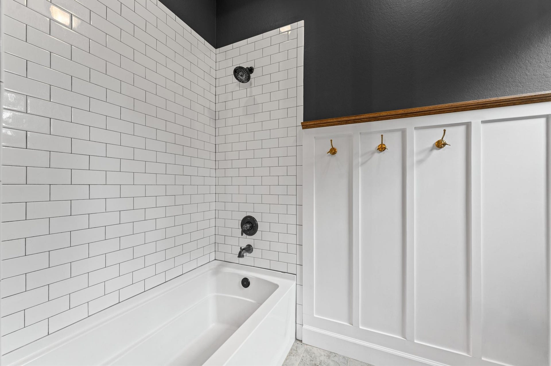 Beautiful tile backsplash detailing and built-in towel holders complement the oversized double-sink vanity, creating a stylish and functional bathroom conveniently shared by the two of the secondary bedrooms.