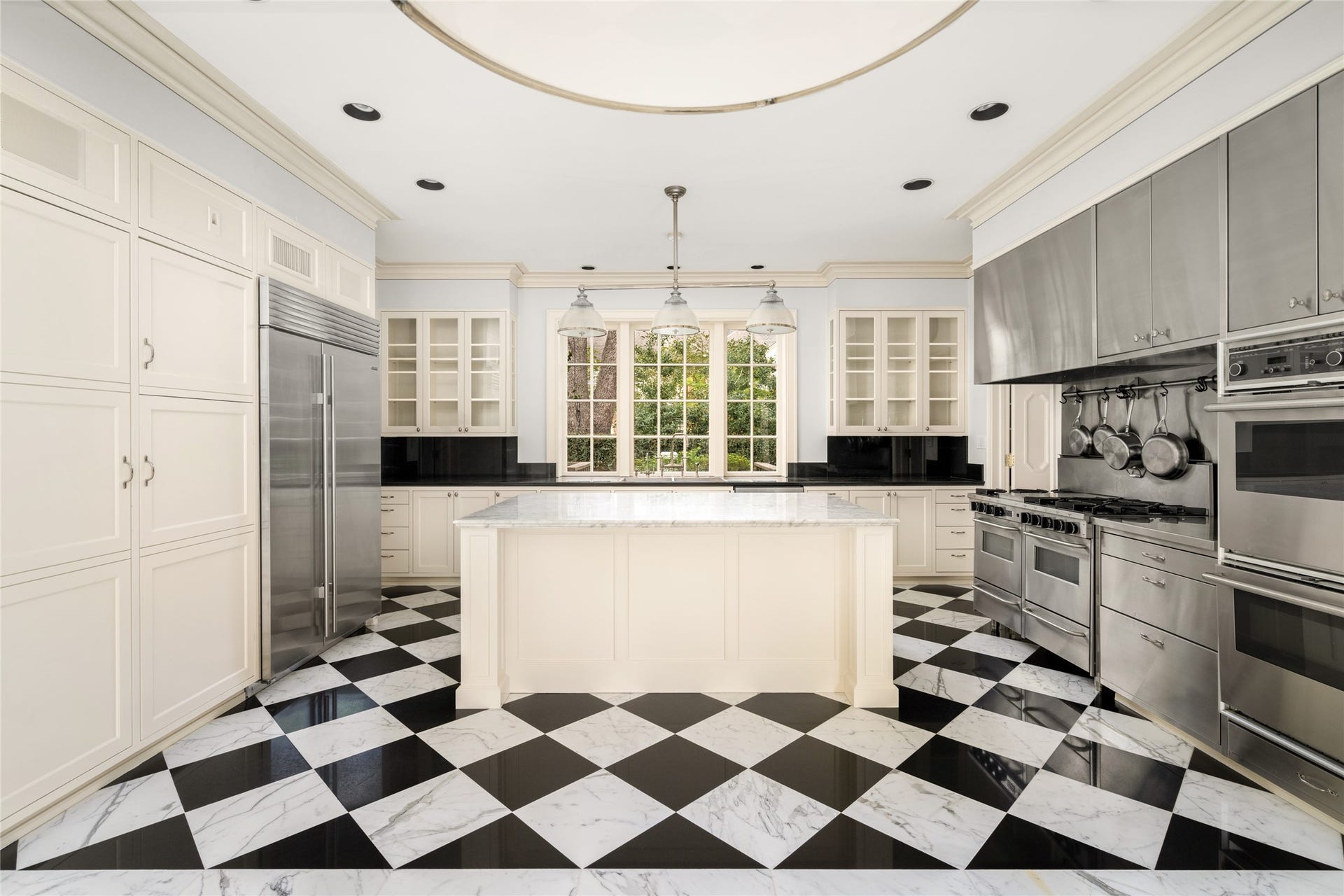 Kitchen with spacious center island, new sub zero refrigerator, double ovens, and windows overlooking the side yard.