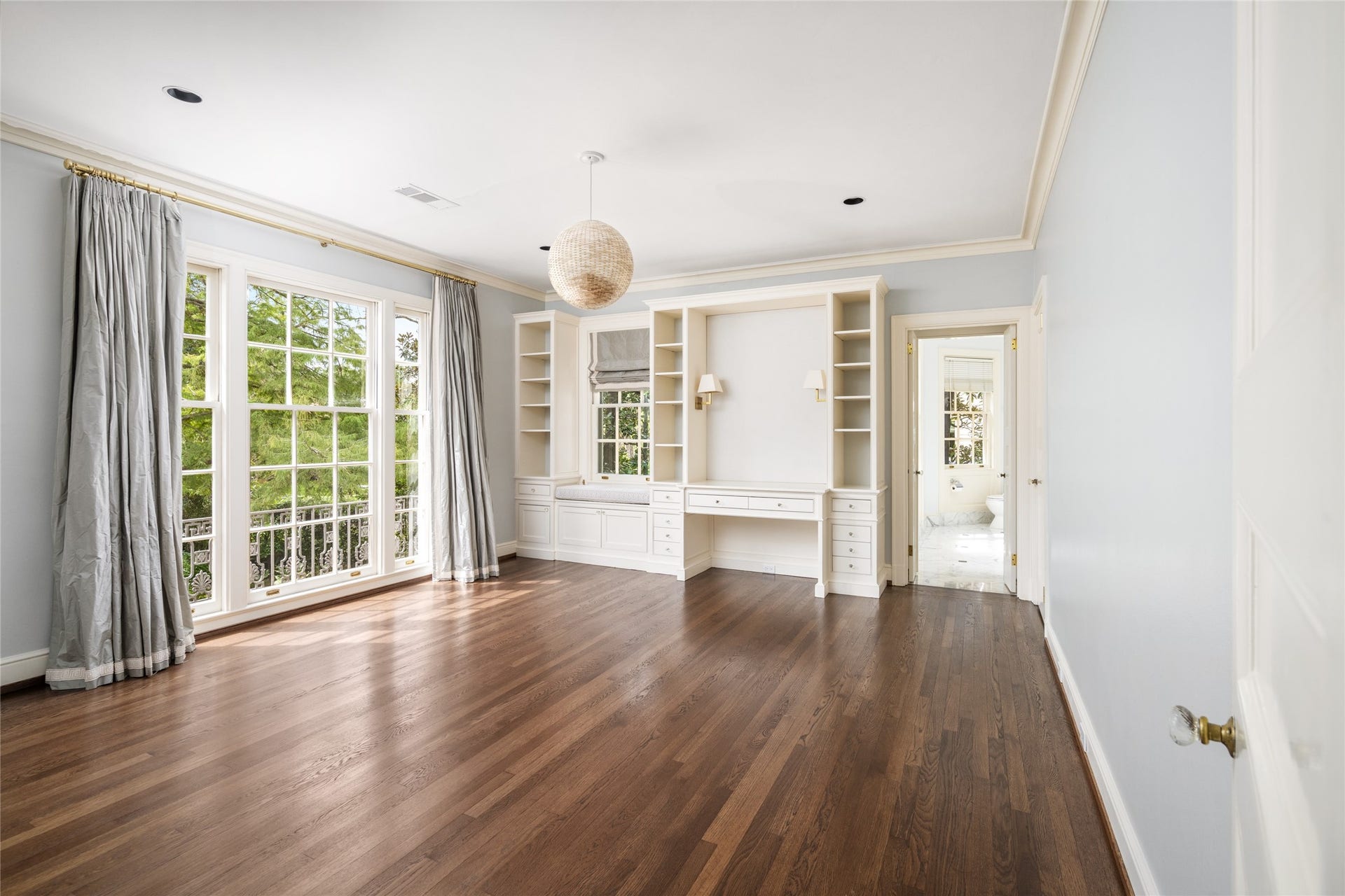 Second bedroom facing the front grounds, with tall windows, built in shelving and desk.