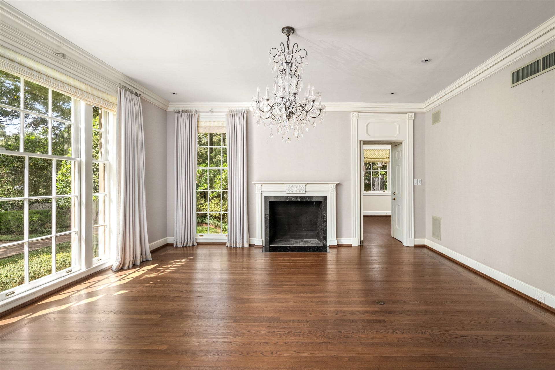 Formal Dinning room with a crystal chandelier, fireplace and large windows overlooking the large front yard.