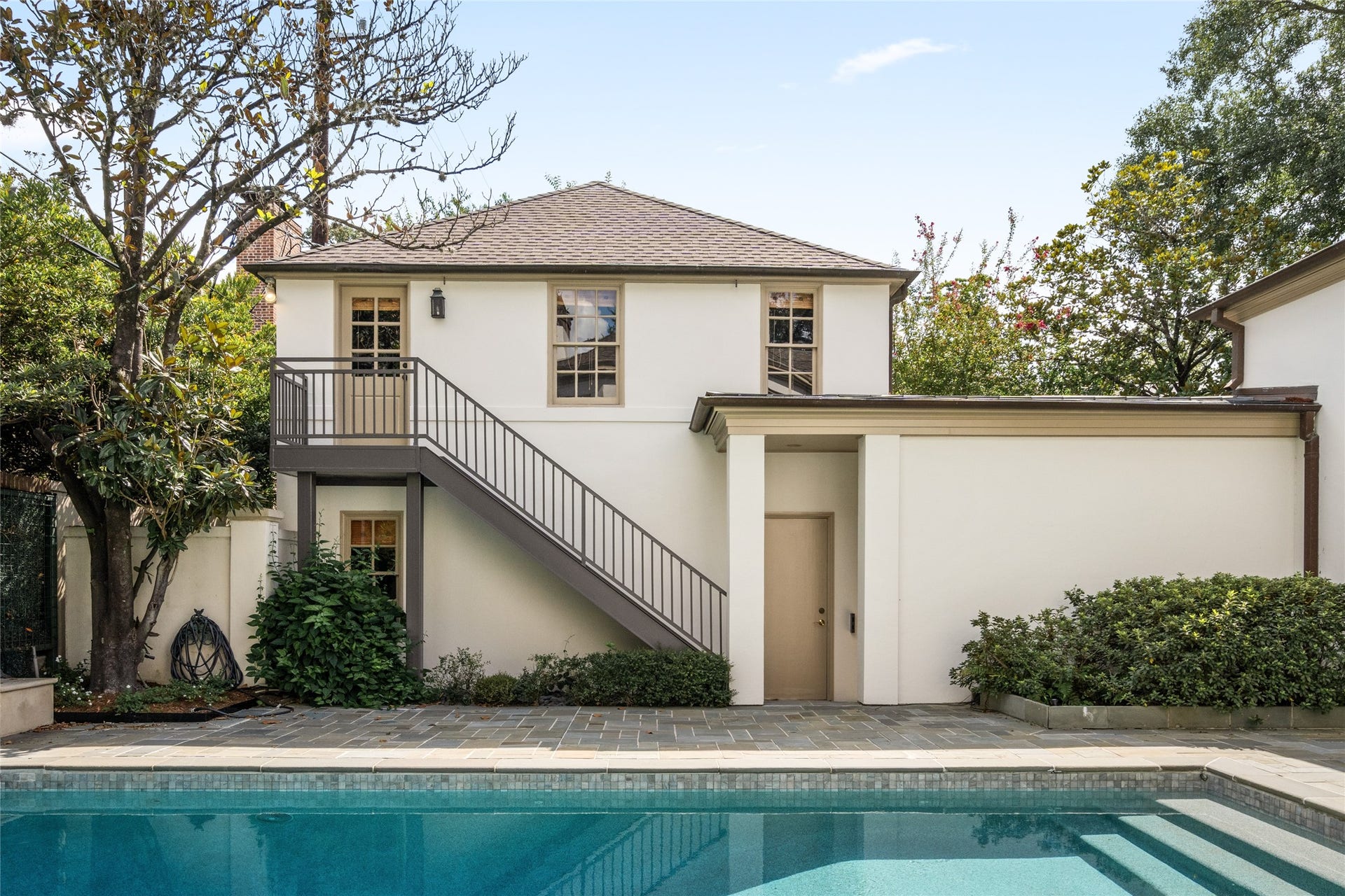 Garage apartment overlooking the pool with a separate exterior staircase.
