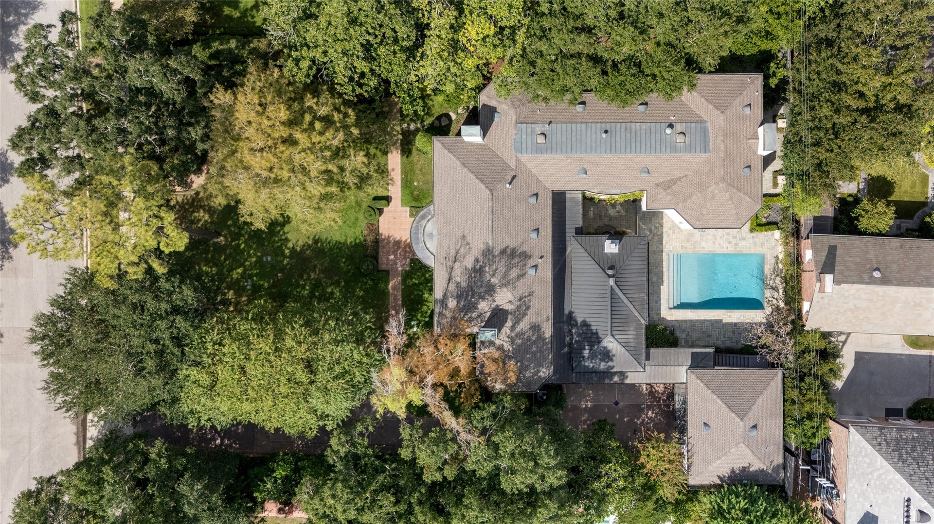 Arial view of 3414 showcasing the estate's expansive footprint, central pool courtyard, and surrounding mature trees, highlighting the homes scale and inviting outdoor spaces.