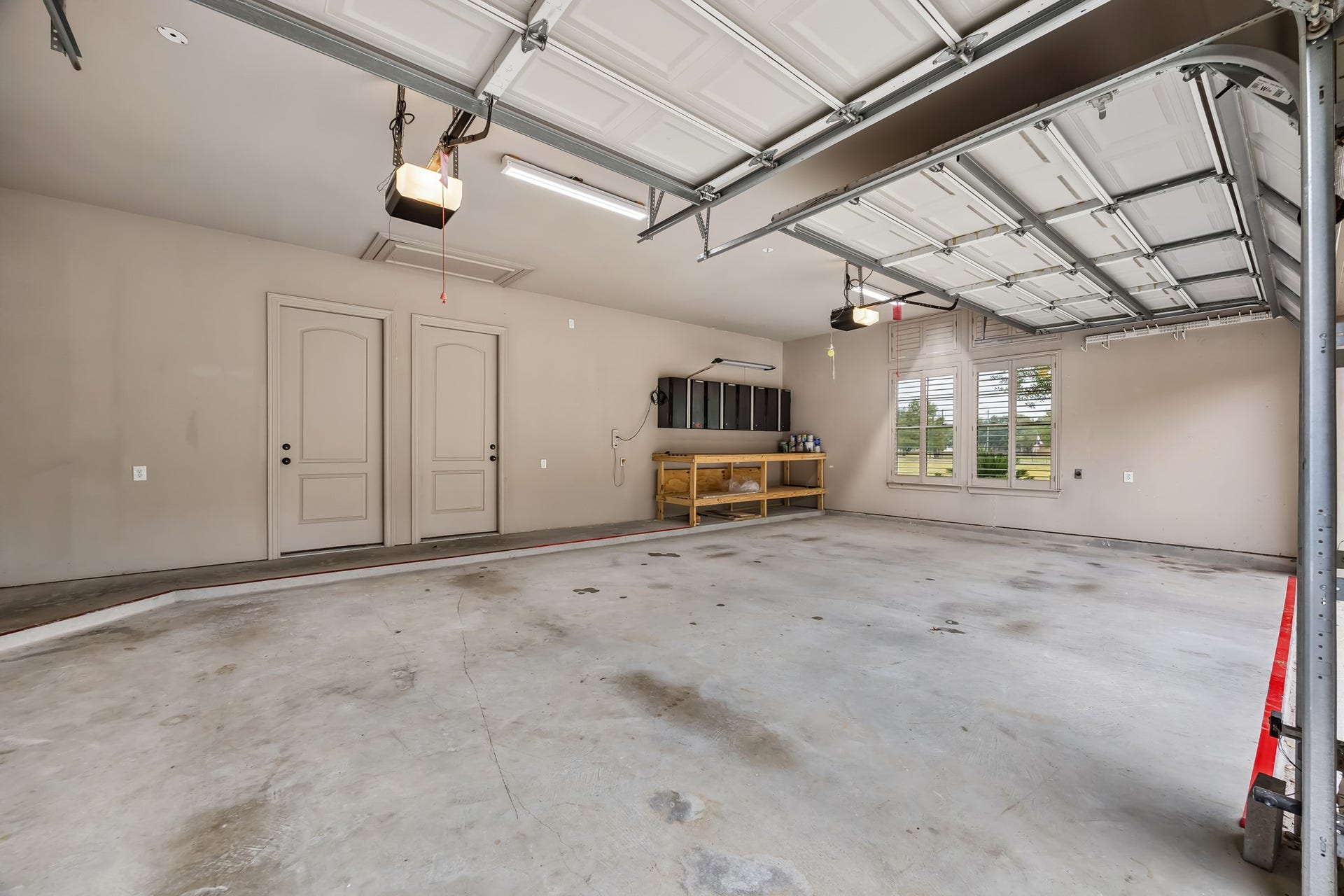 Spacious three-car garage featuring ample storage and bright windows for natural light.