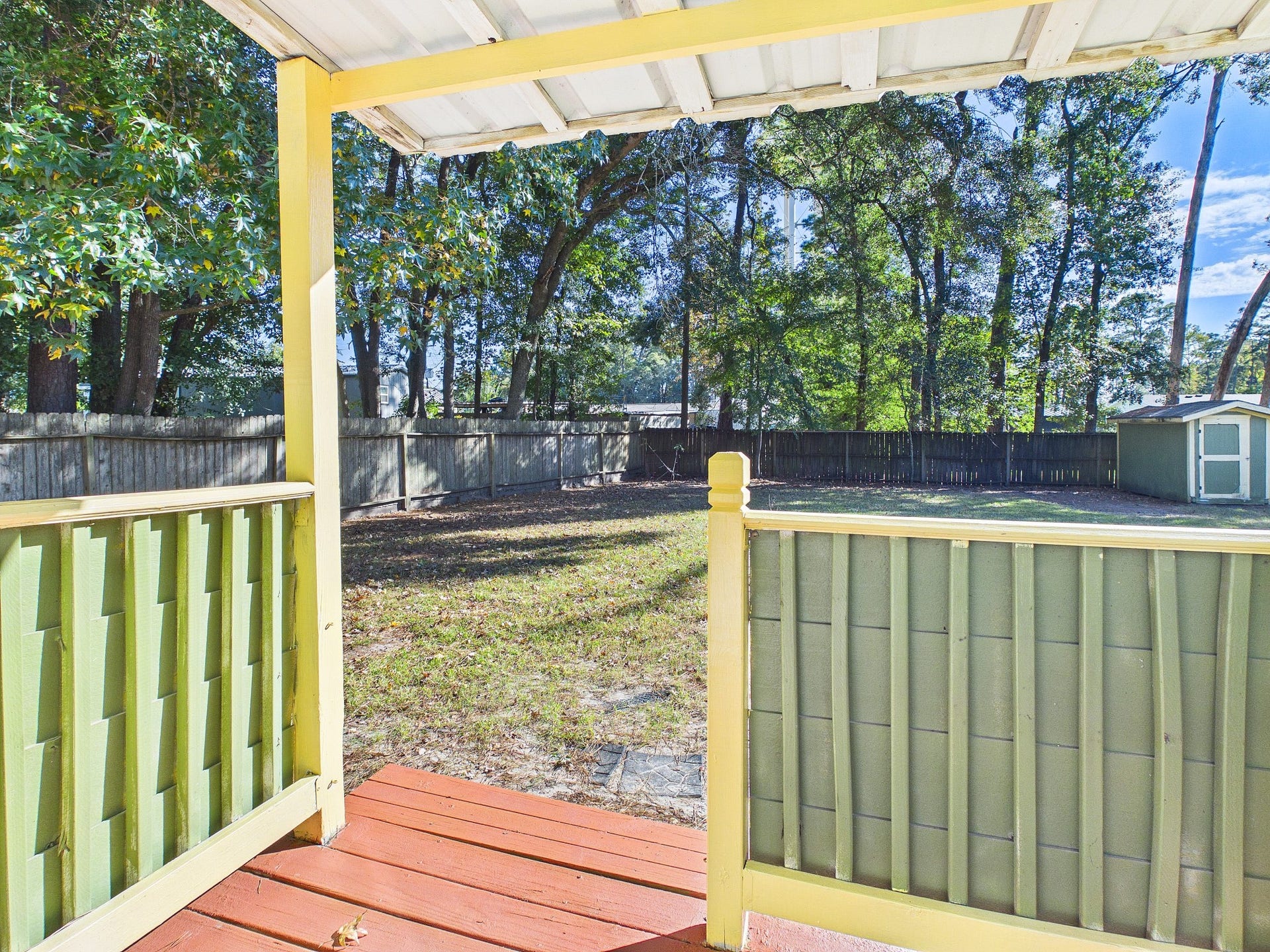 22054 Spears Road, Porter, TX 77365 Charming porch overlooking a spacious, tree-lined backyard, perfect for outdoor relaxation and privacy.