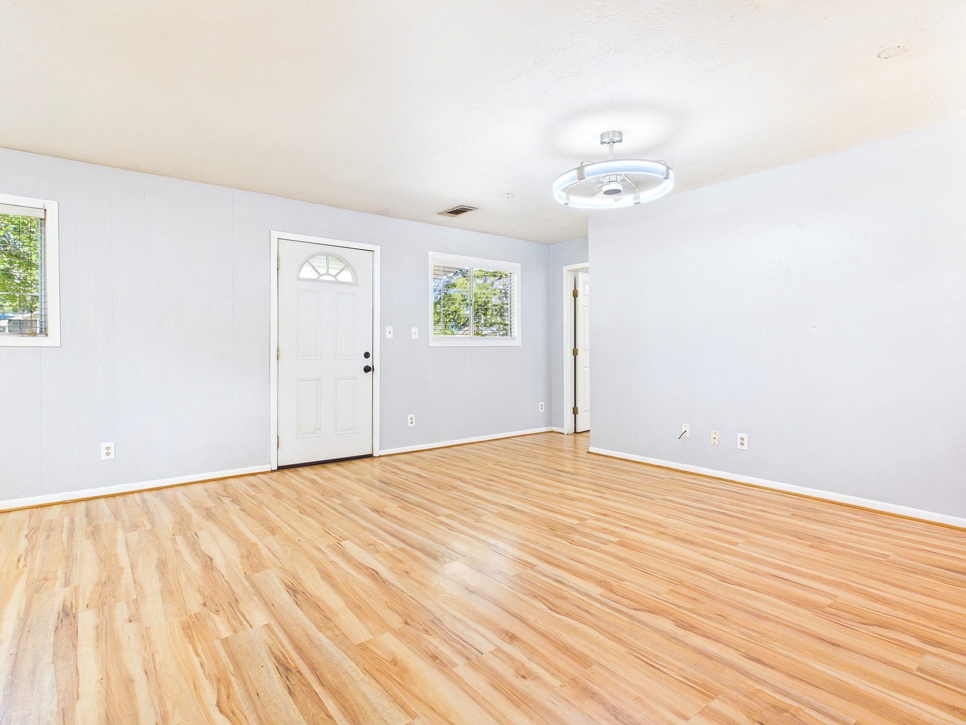 22054 Spears Road, Porter, TX 77365 Bright and inviting living space with sleek wood-look floors, modern light fixtures, and ample natural light from large windows.