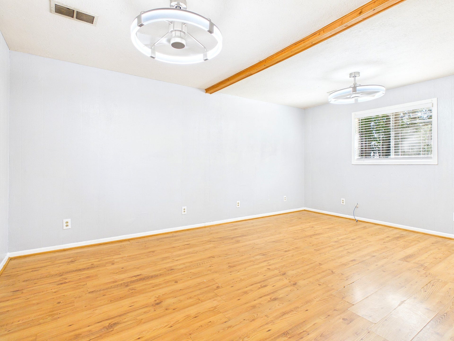 22054 Spears Road, Porter, TX 77365 Bright and spacious room featuring sleek floors, modern light fixtures, and a large window that invites ample natural light.